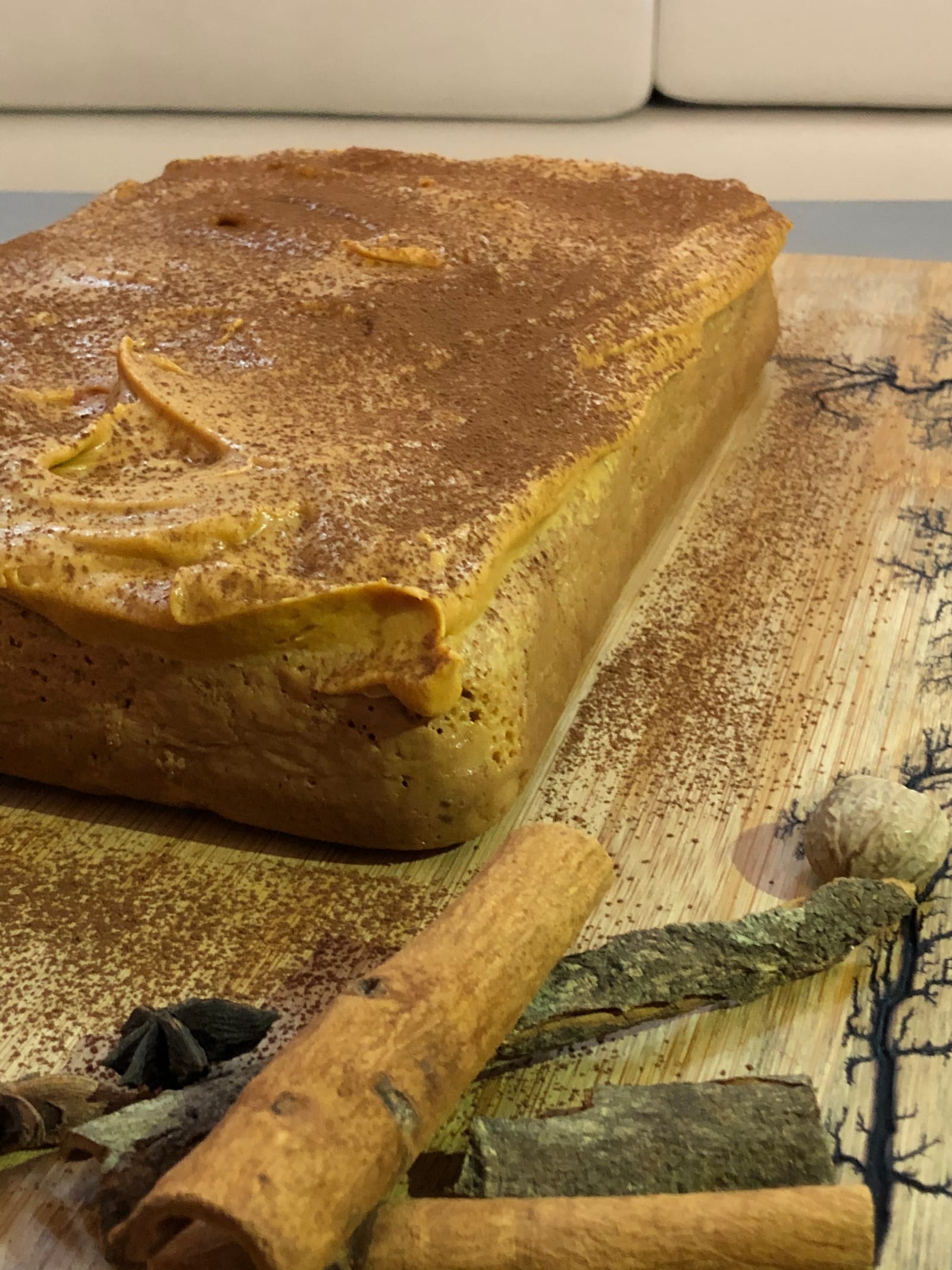 Close-up of the corner of a masala tres leches cake with cinnamon sticks