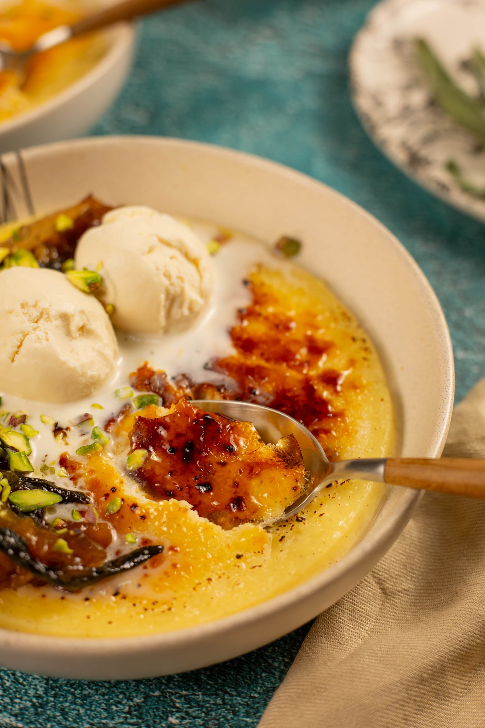 A spoon breaking into the brûléed rice pudding