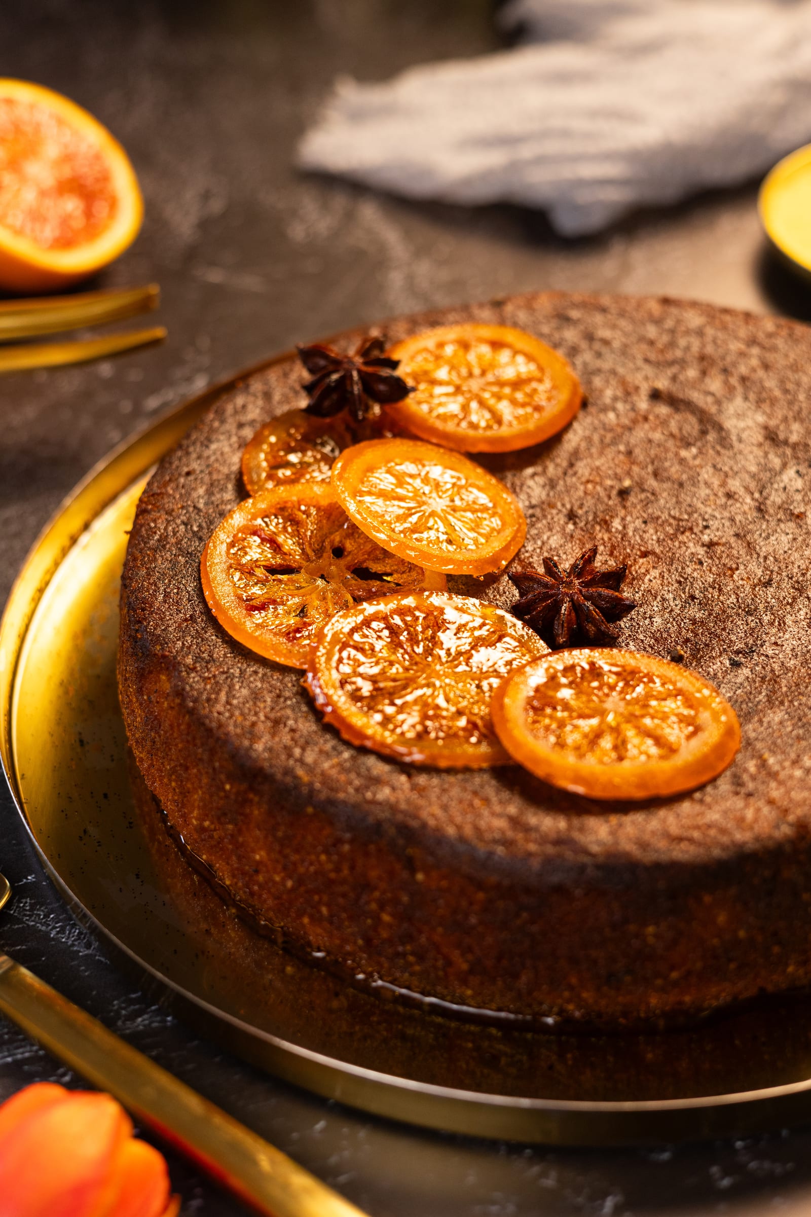 Close-up of candied blood orange slices and star anise on the cake