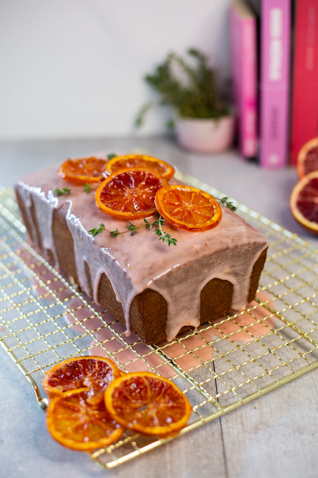 A cream cheese pound cake with blood orange glaze, topped with candied blood orange slices and thyme