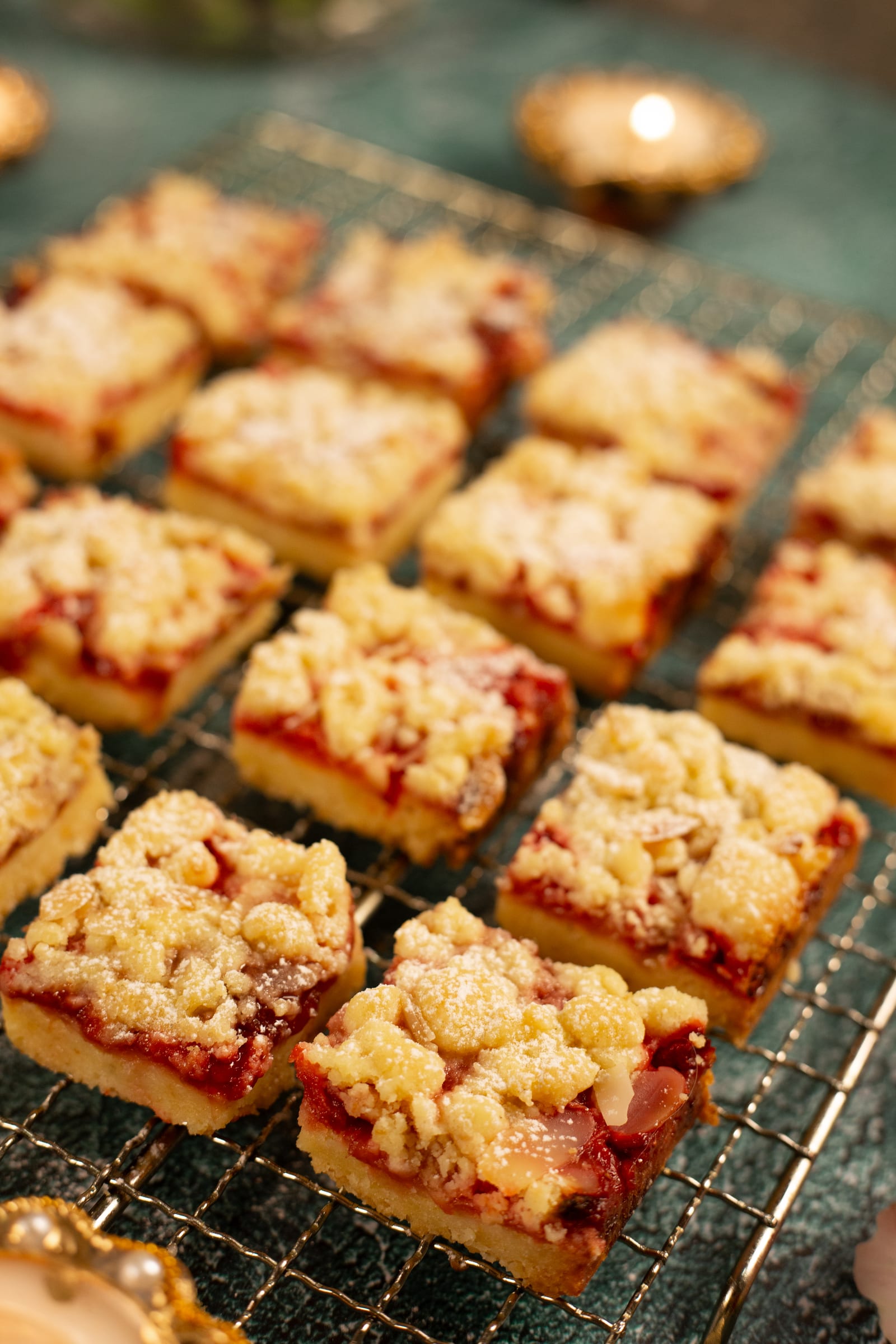 Hungarian tart squares lined up on a rack, with a candle
