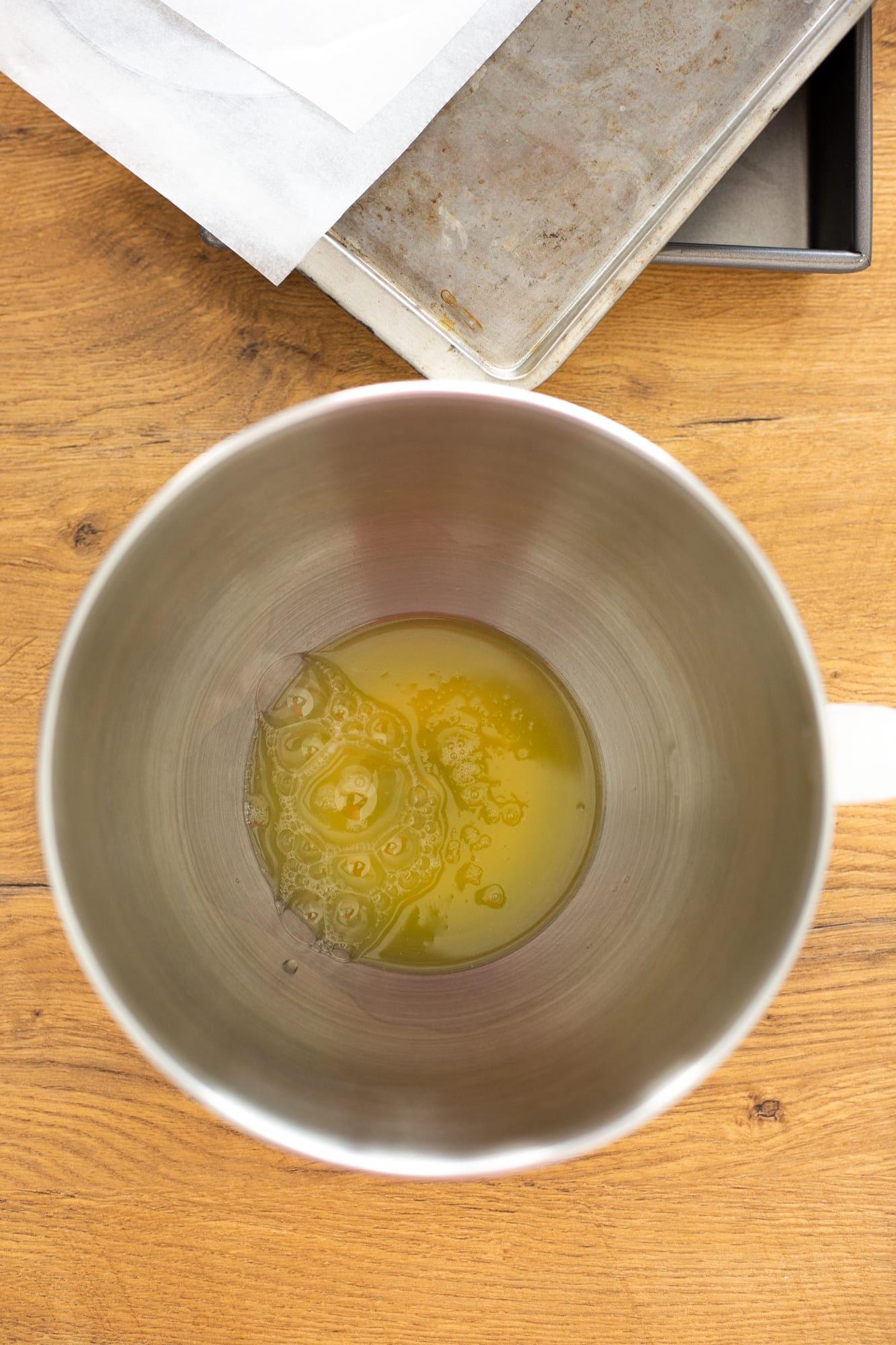 Egg whites in a steel mixing bowl for the meringue, from above