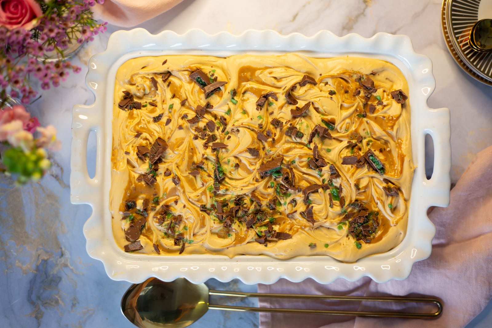 Peppermint Crisp tart from above in a white dish, swirled with caramel and scattered with chopped chocolate