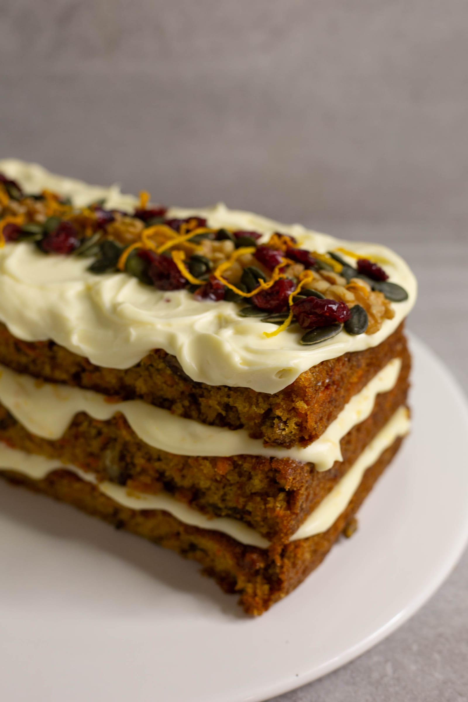 The end of the layered carrot cake with its walnut, cranberry and seed topping