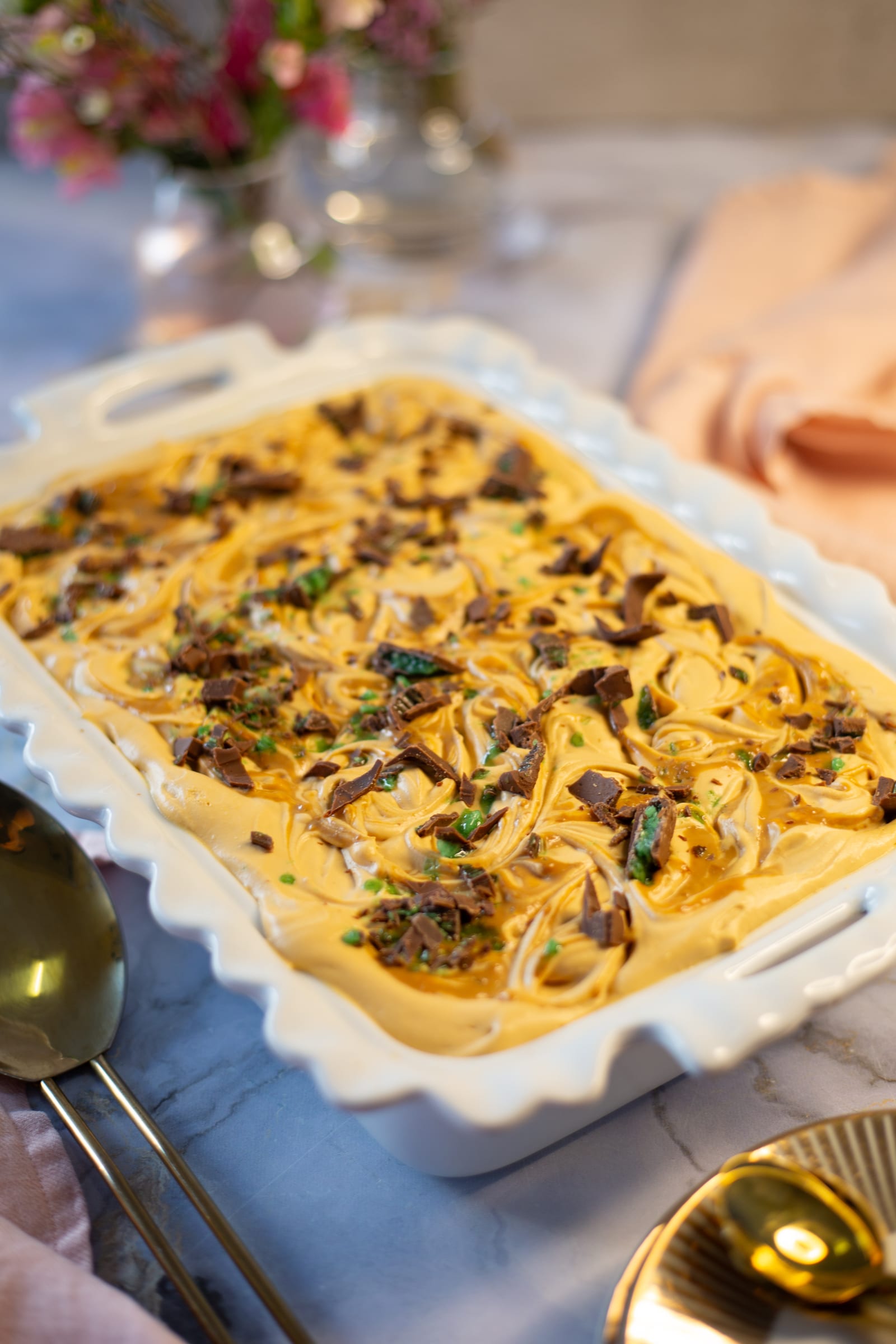 A Peppermint Crisp tart in its white dish, with gold spoons beside it