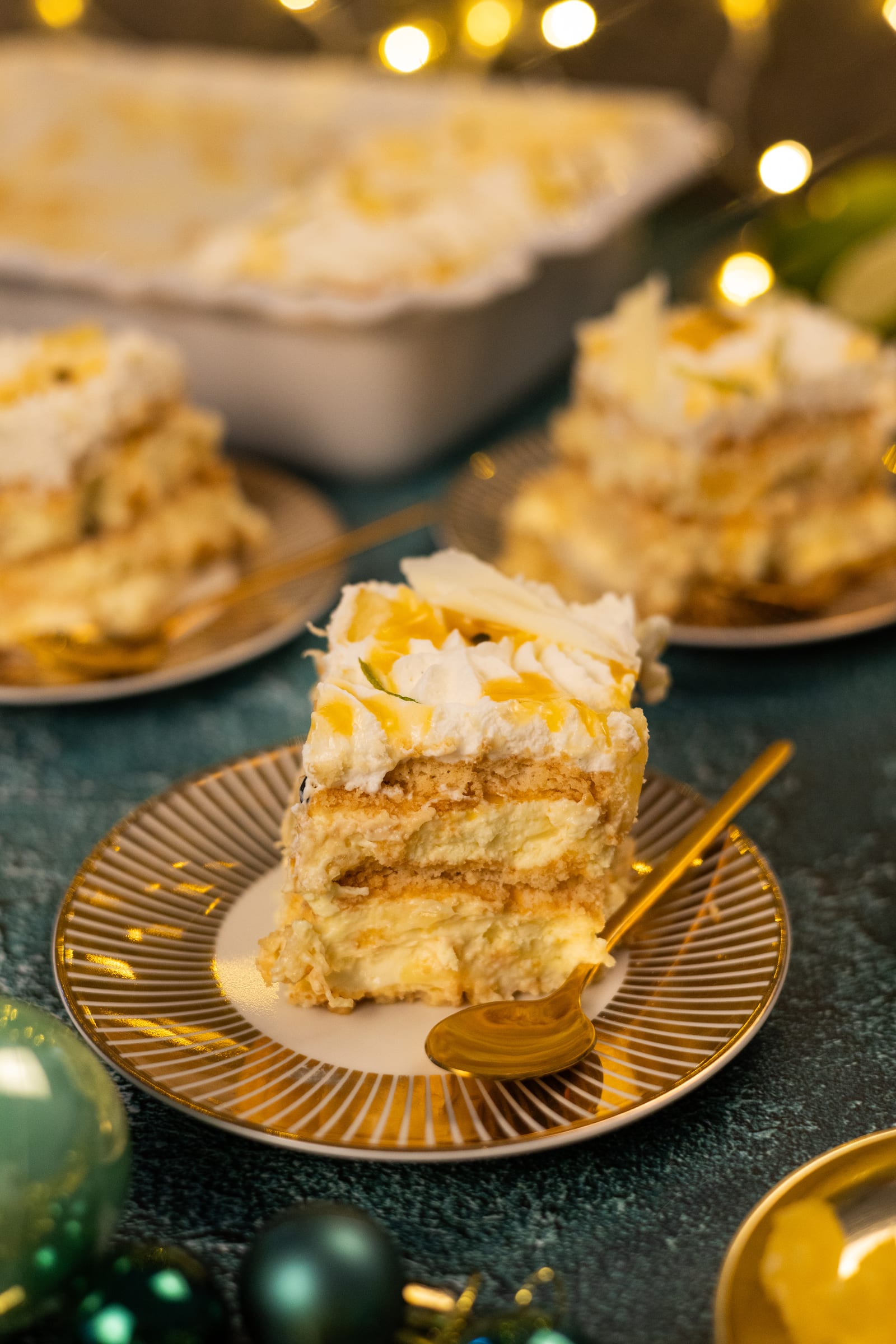 A slice of fridge tart on a gold plate, with the dish behind