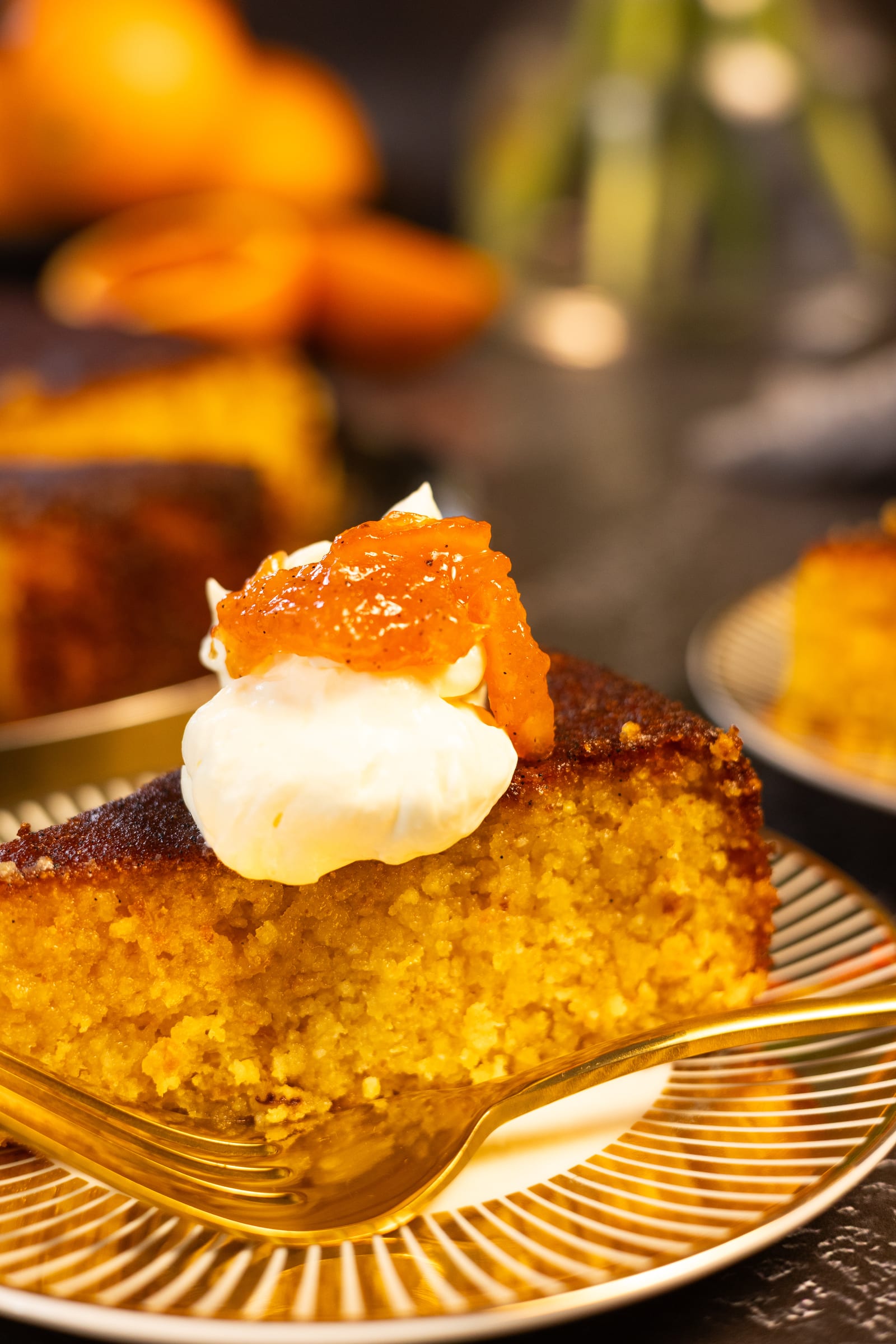 Close-up of a slice of cake topped with cream and blood orange marmalade