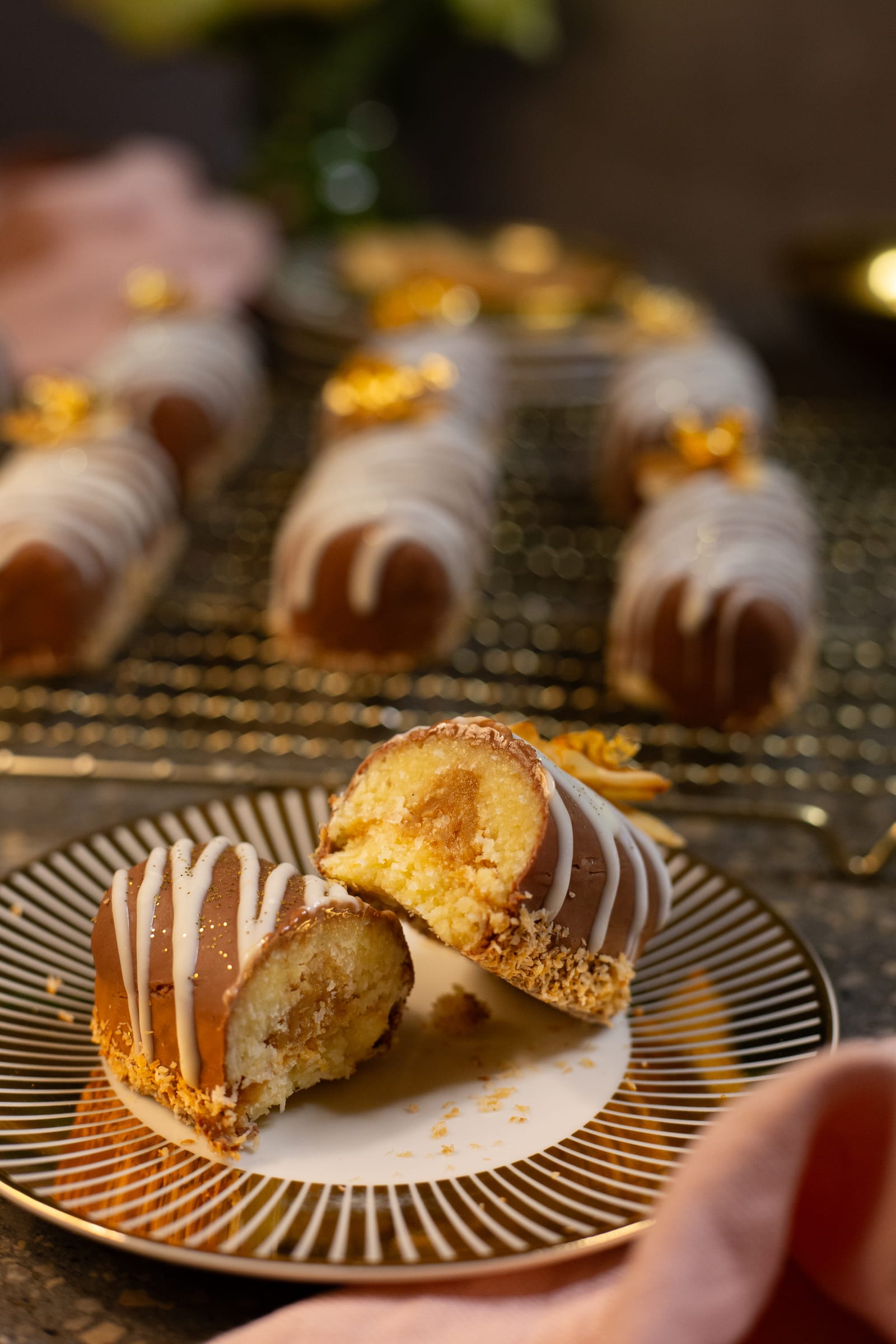 A coconut, caramel and chocolate log cut open on a plate, showing the caramel centre