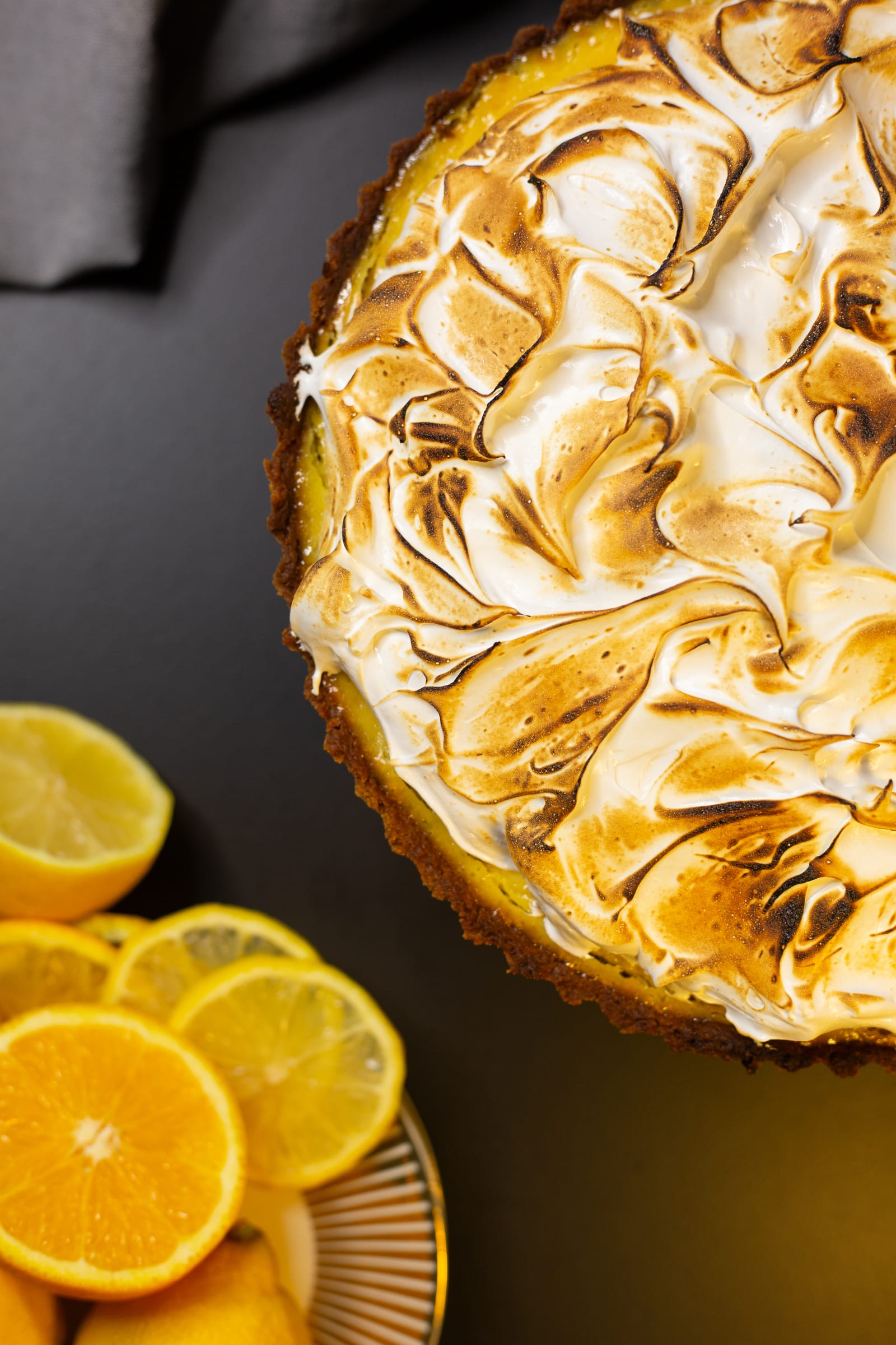 Close-up of toasted meringue swirls, with orange slices
