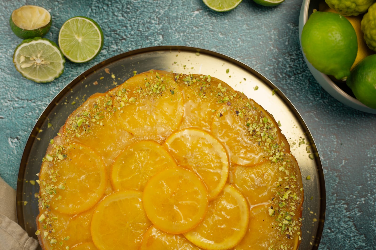 An orange and olive oil upside down cake from above, glossy navel orange slices fanned over the top