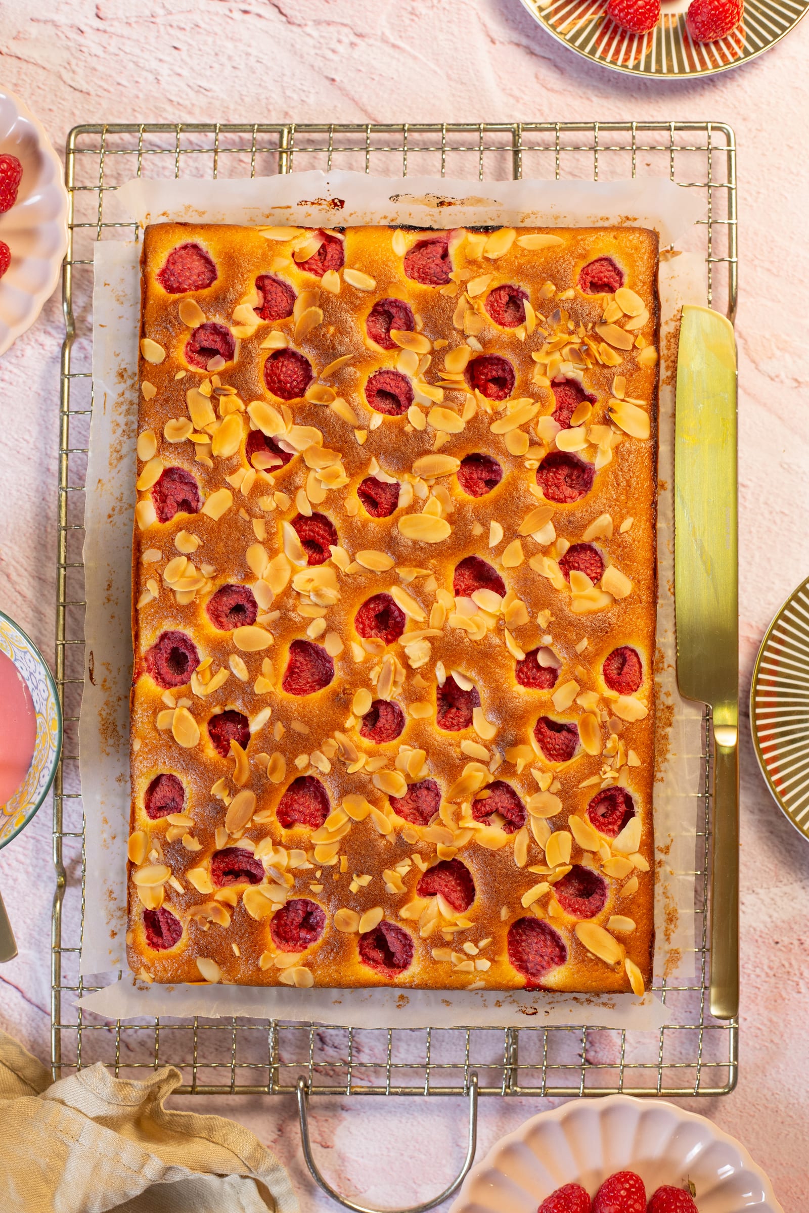 The baked snack cake on a wire rack with a gold knife, from above