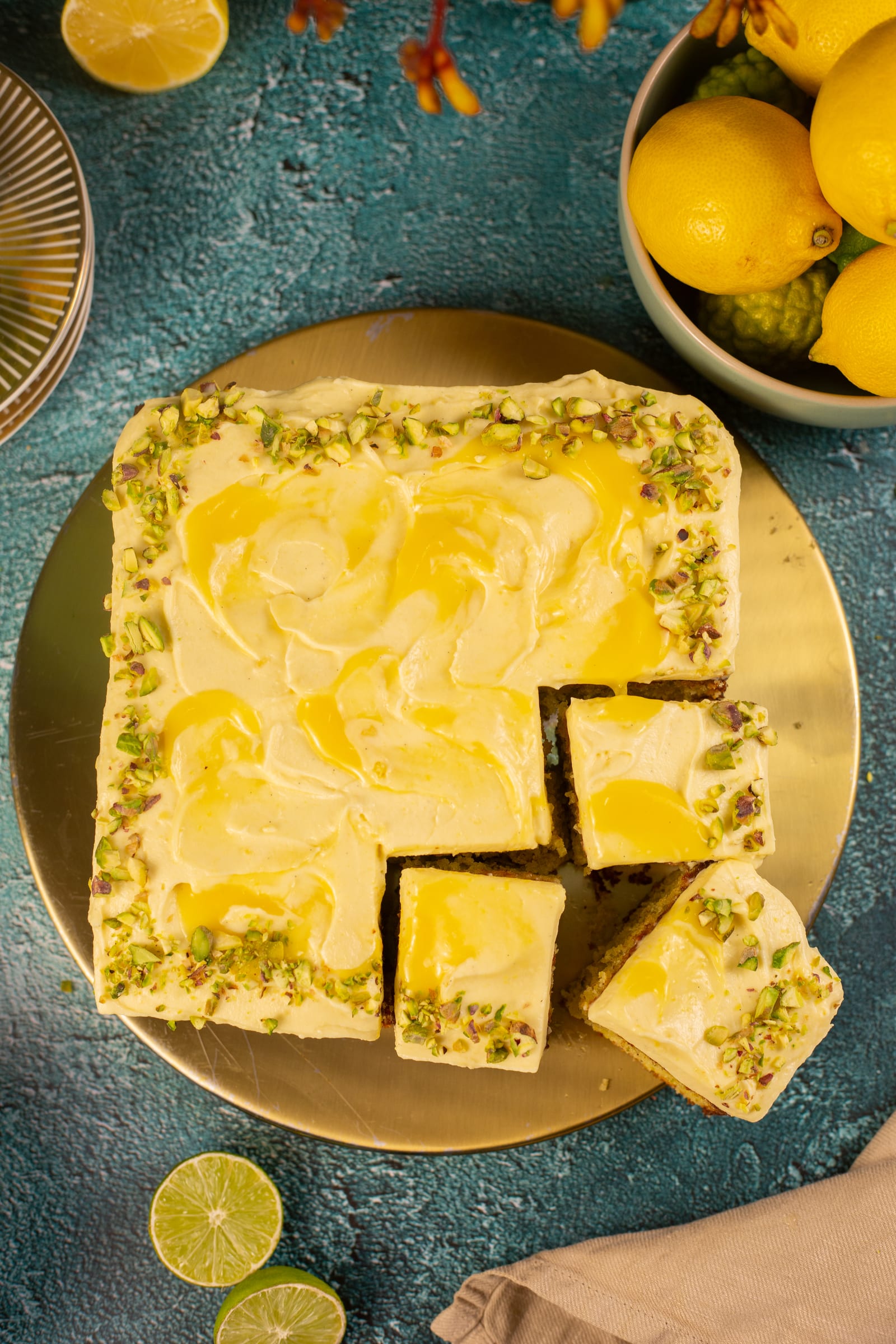 The pistachio and lemon traybake from above, with a few squares cut and lifted out