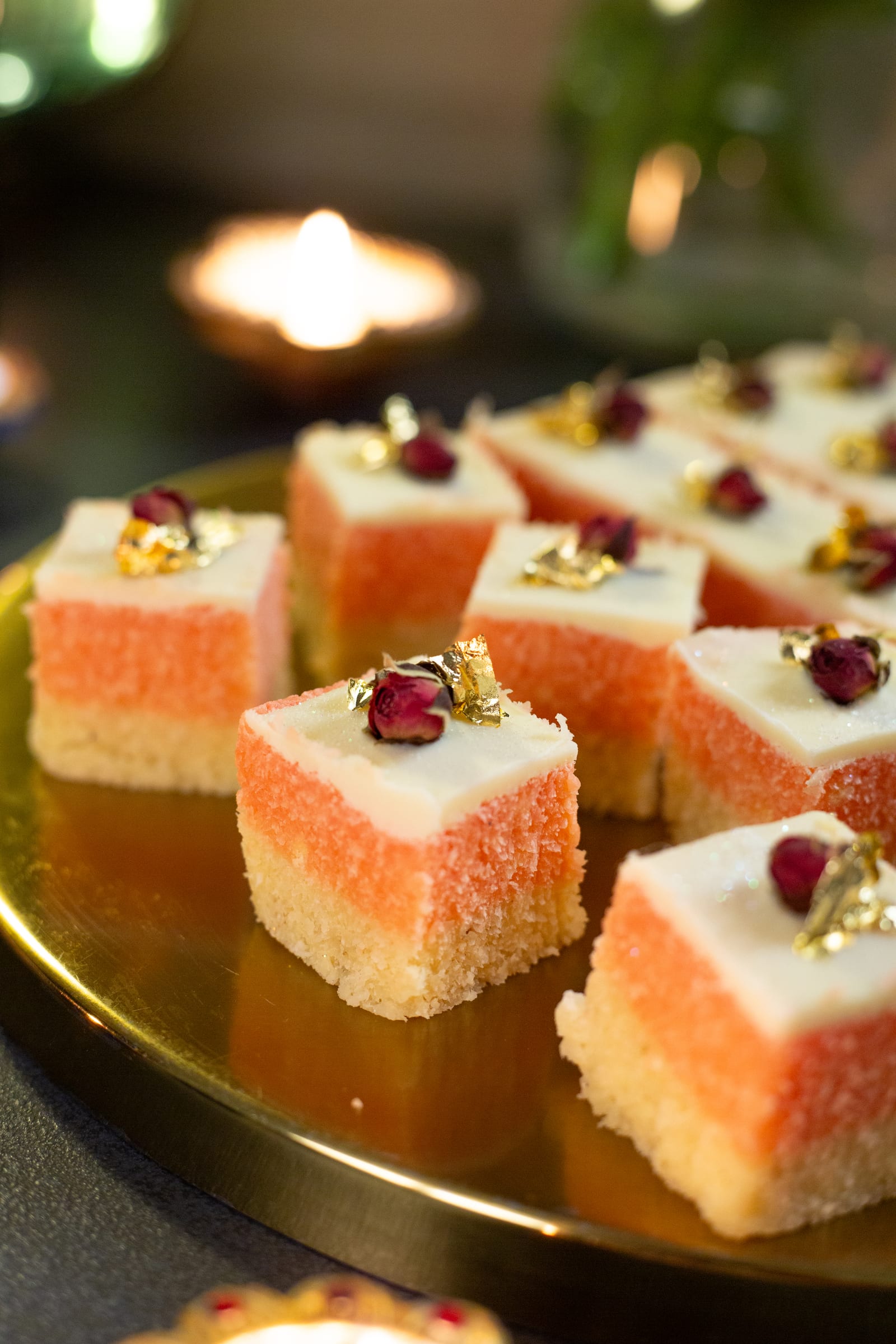 Close-up of rose burfee squares topped with dried rose buds