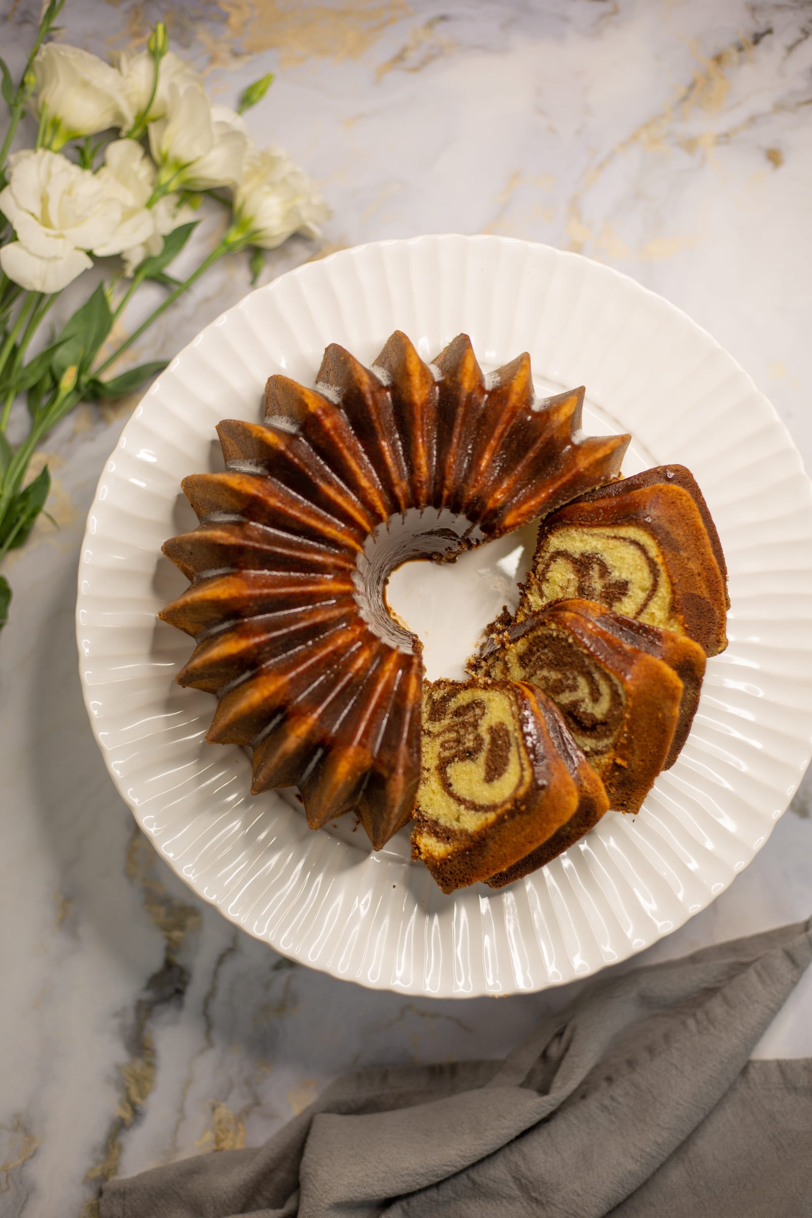 The marble pound cake from above with a wedge cut out, showing the marbled crumb