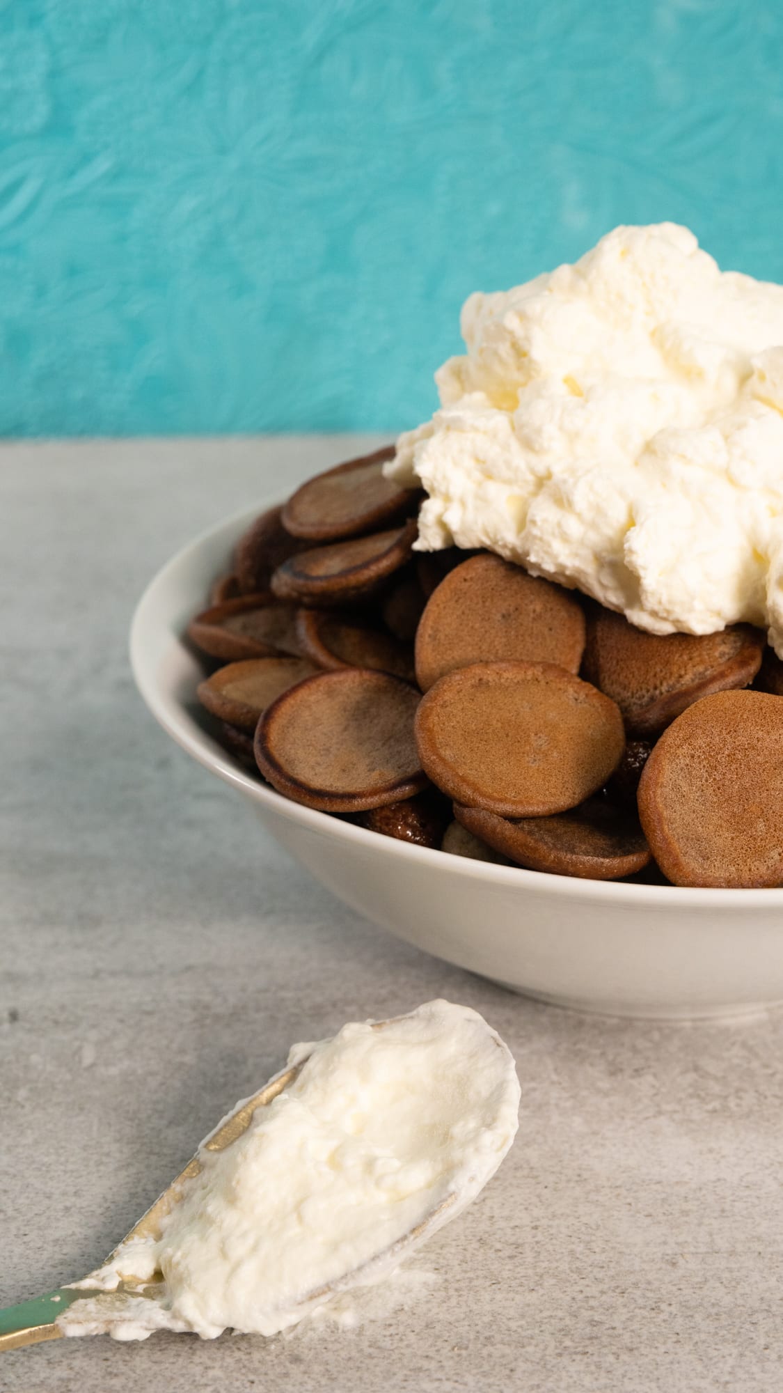 A bowl of Milo pancake cereal topped with cream, a spoonful of cream in front
