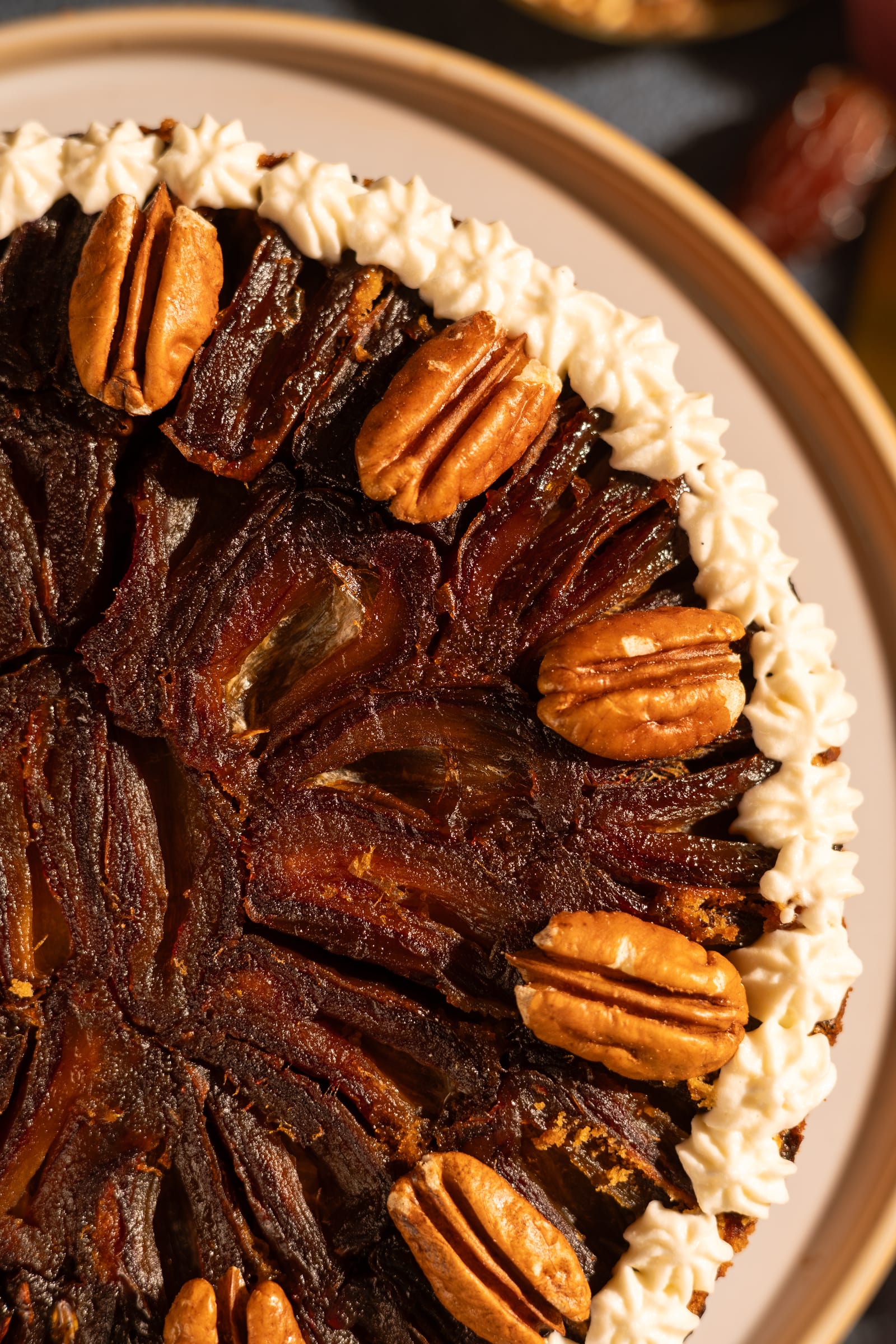 Close-up of caramelised pecans and piped cream on the cake