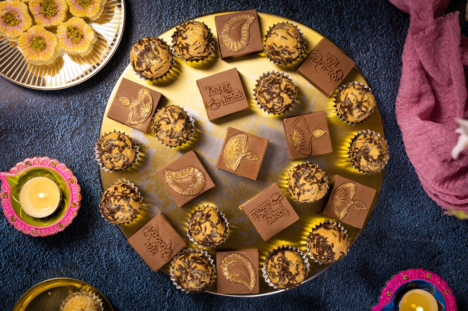 Caramel and chocolate Simply Wonderfuls on a round gold platter surrounded by diyas, from above
