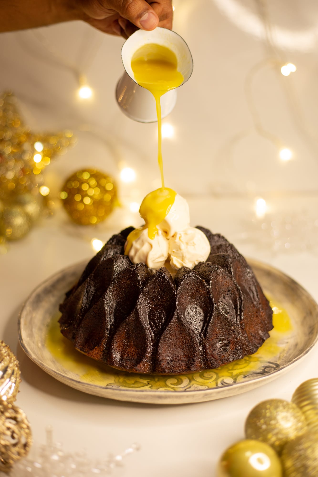 Custard being poured over a gingerbread bundt pudding