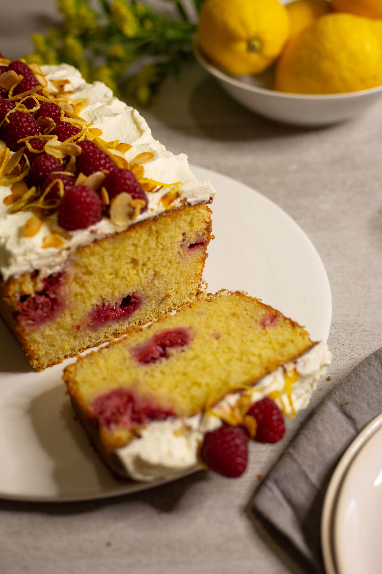 A gluten-free almond, raspberry and lemon loaf with slices cut, from slightly above