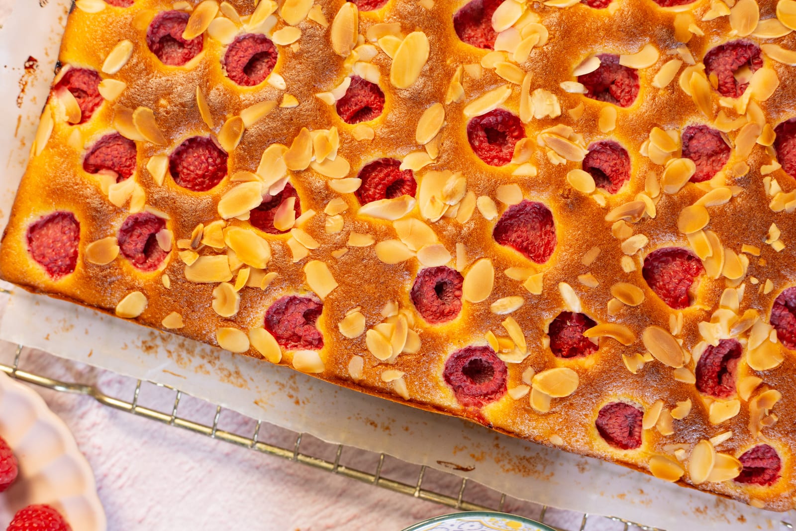 Close-up of raspberries and toasted flaked almonds on the cake