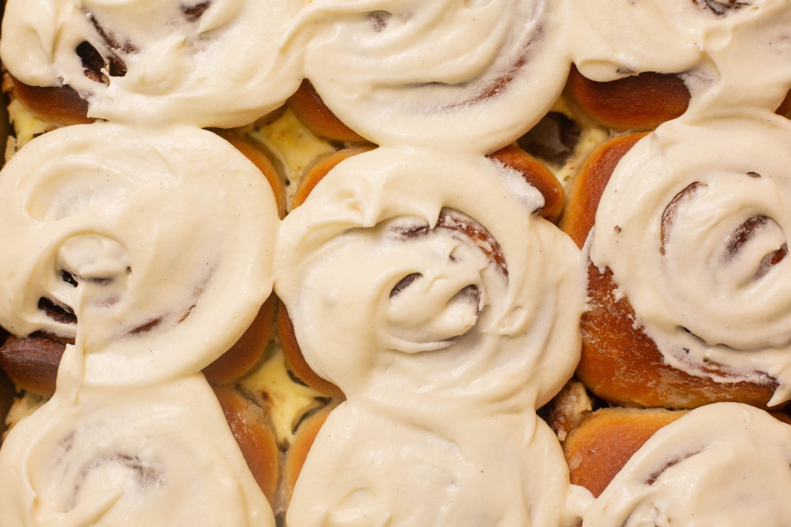 Close-up of soft cinnamon rolls covered in cream cheese icing