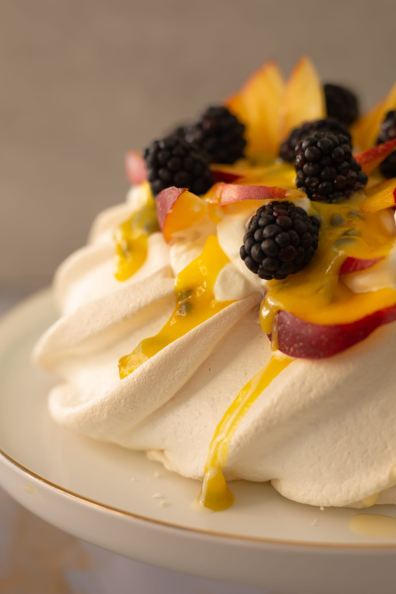 Passionfruit dripping down the meringue swirls beneath blackberries