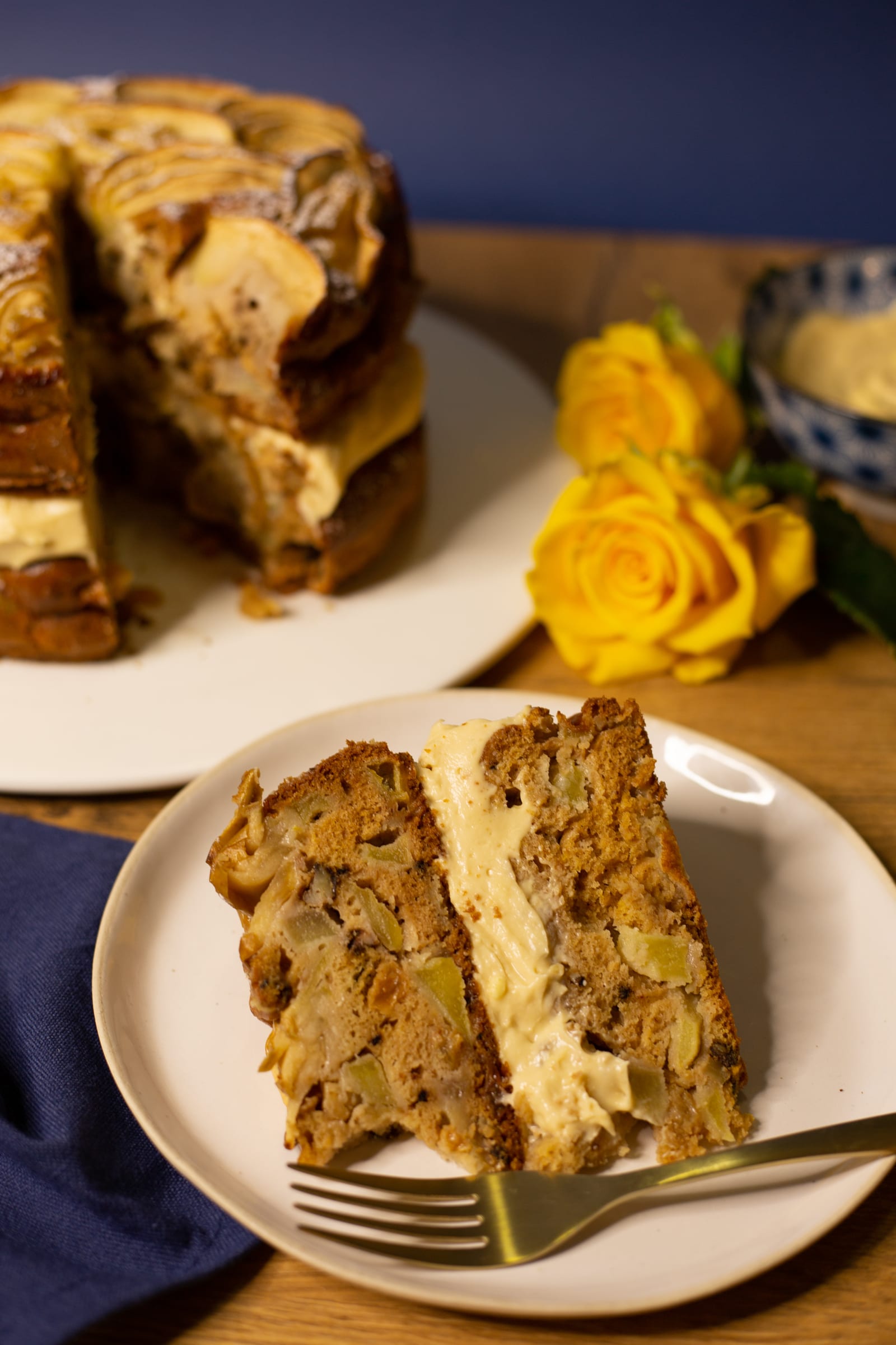 A slice of apple and olive oil cake with a fork in front of the cut cake