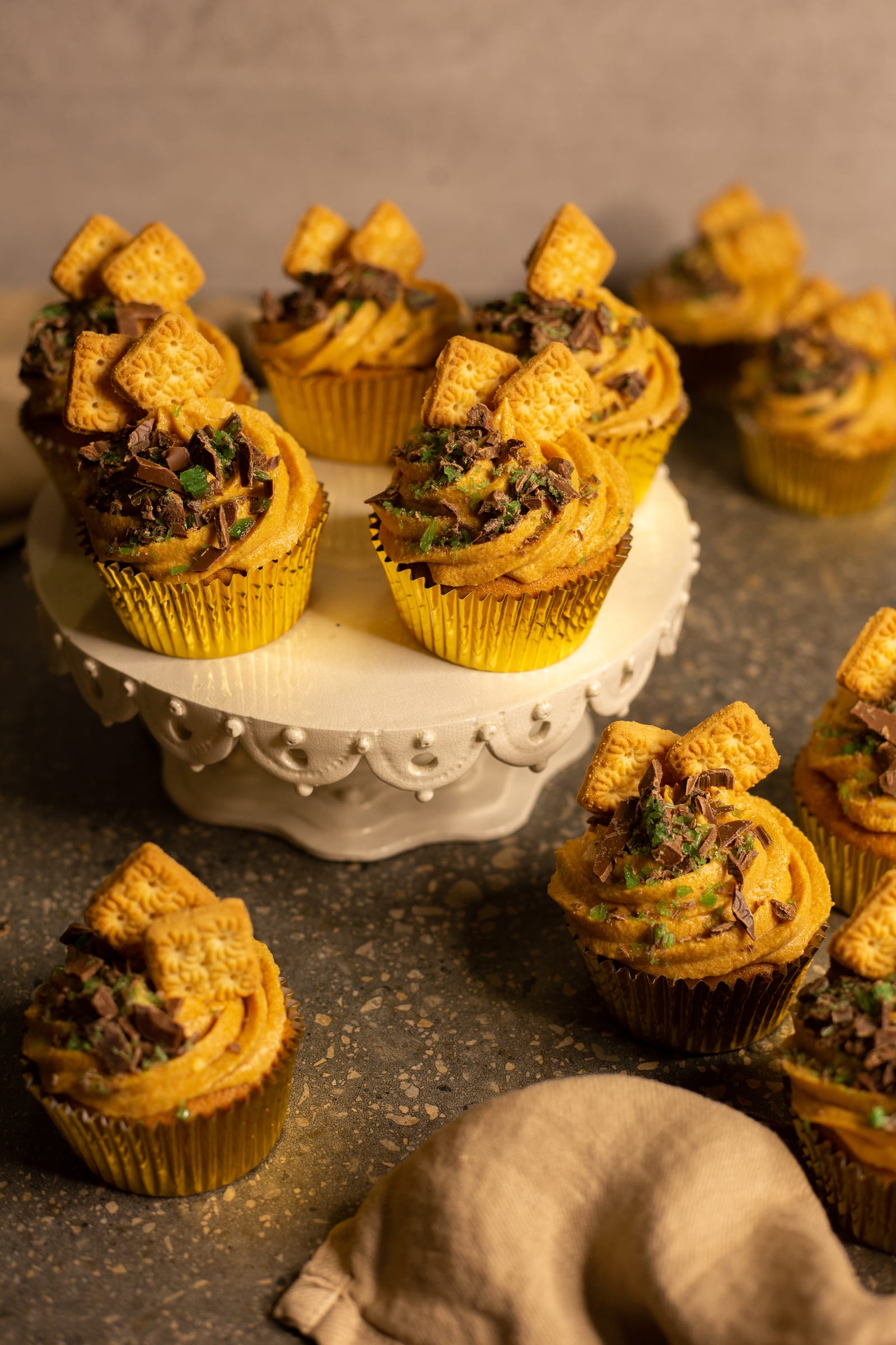 Peppermint crisp tart cupcakes on a white cake stand and scattered around it