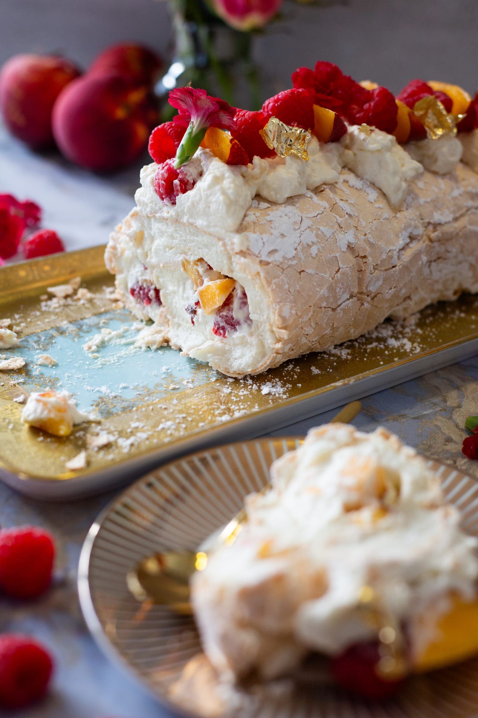 The roulade cut open to show the cream filling, with a slice on a plate in front