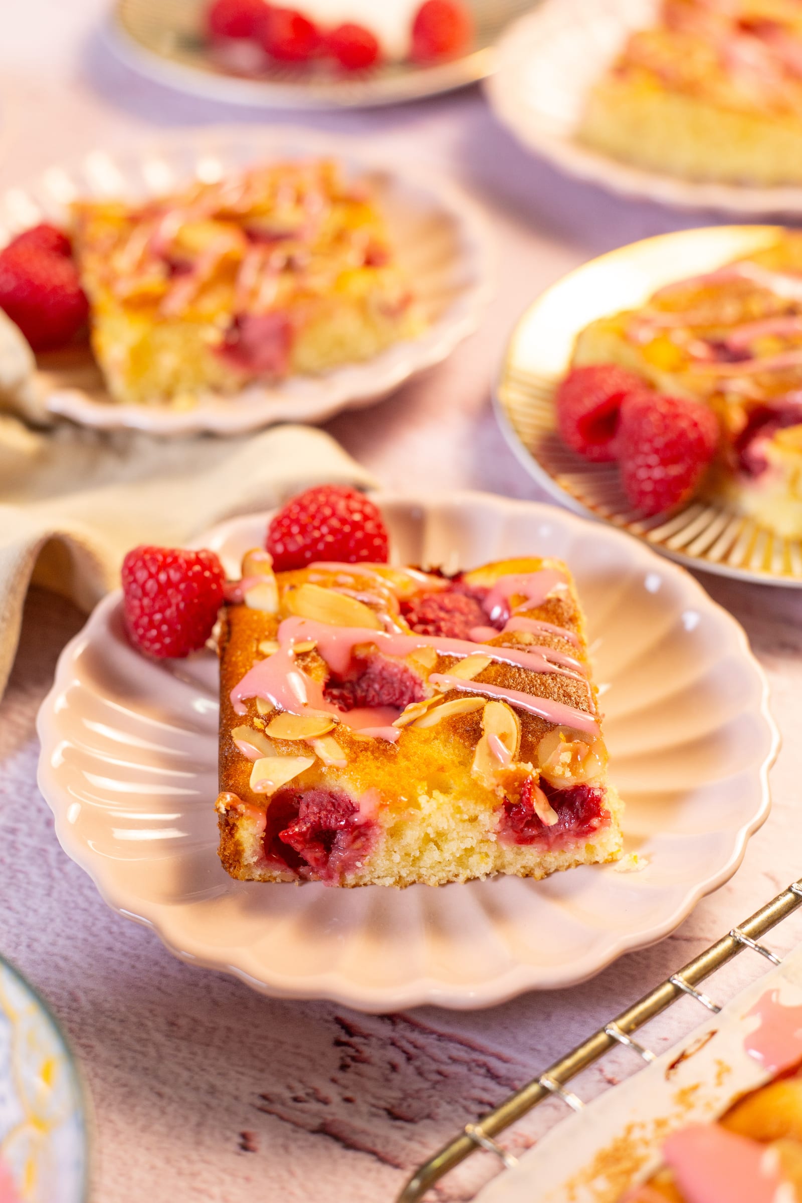 A square of raspberry snack cake on a pink scalloped plate
