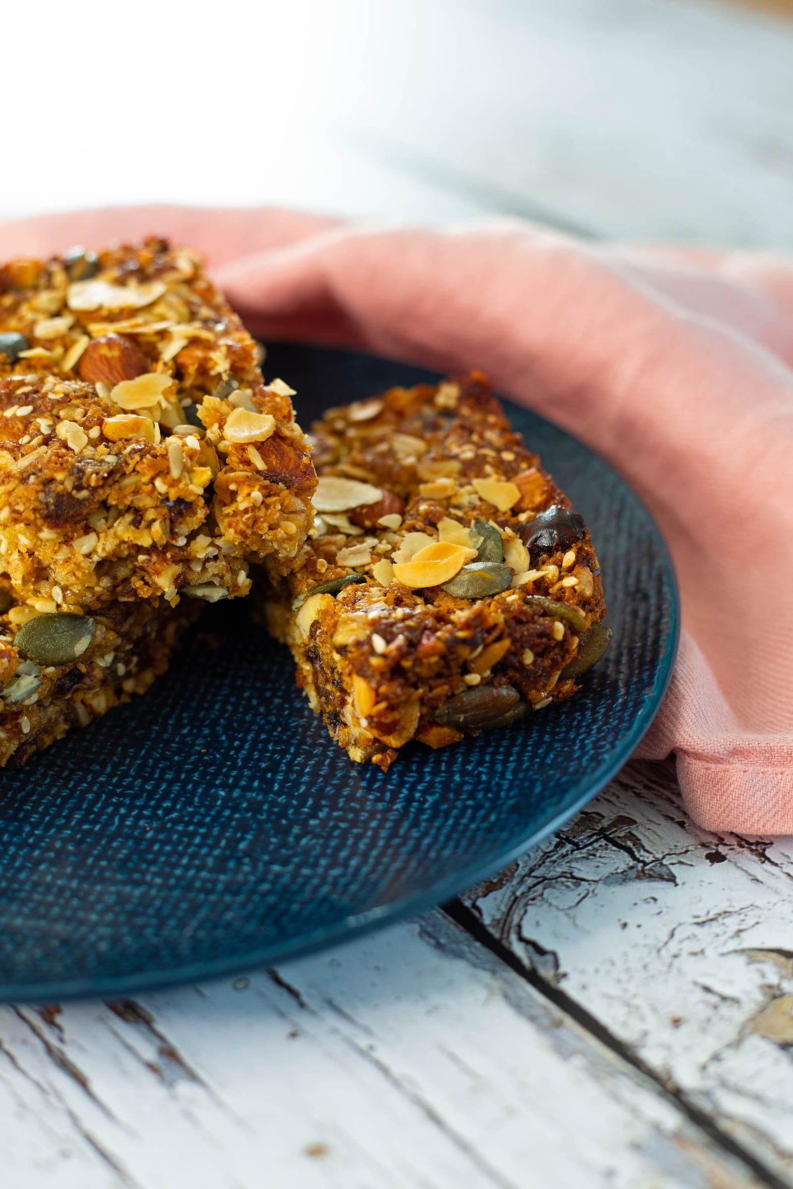 Close-up of stacked date and nut caramel bars, showing the nuts and seeds