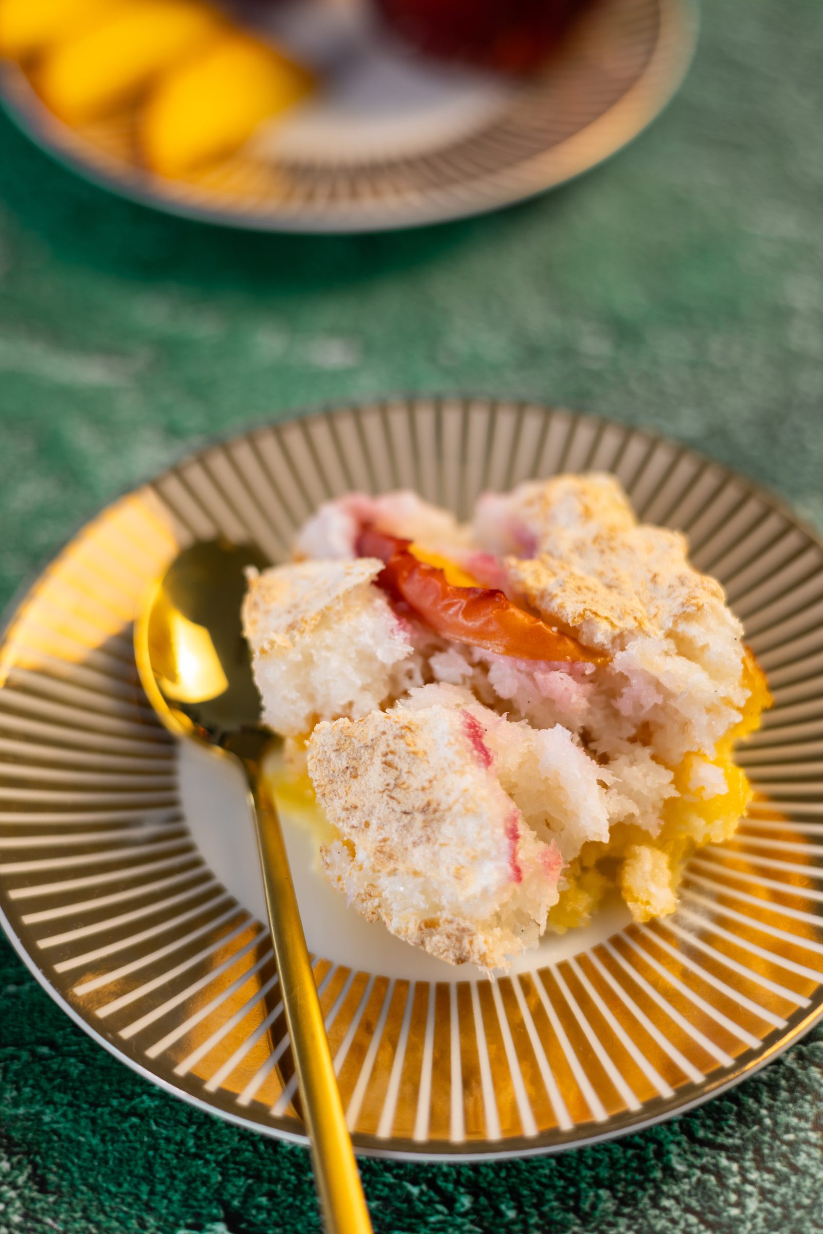 A serving of Fehmz coconut pudding on a gold-rimmed plate with a gold spoon