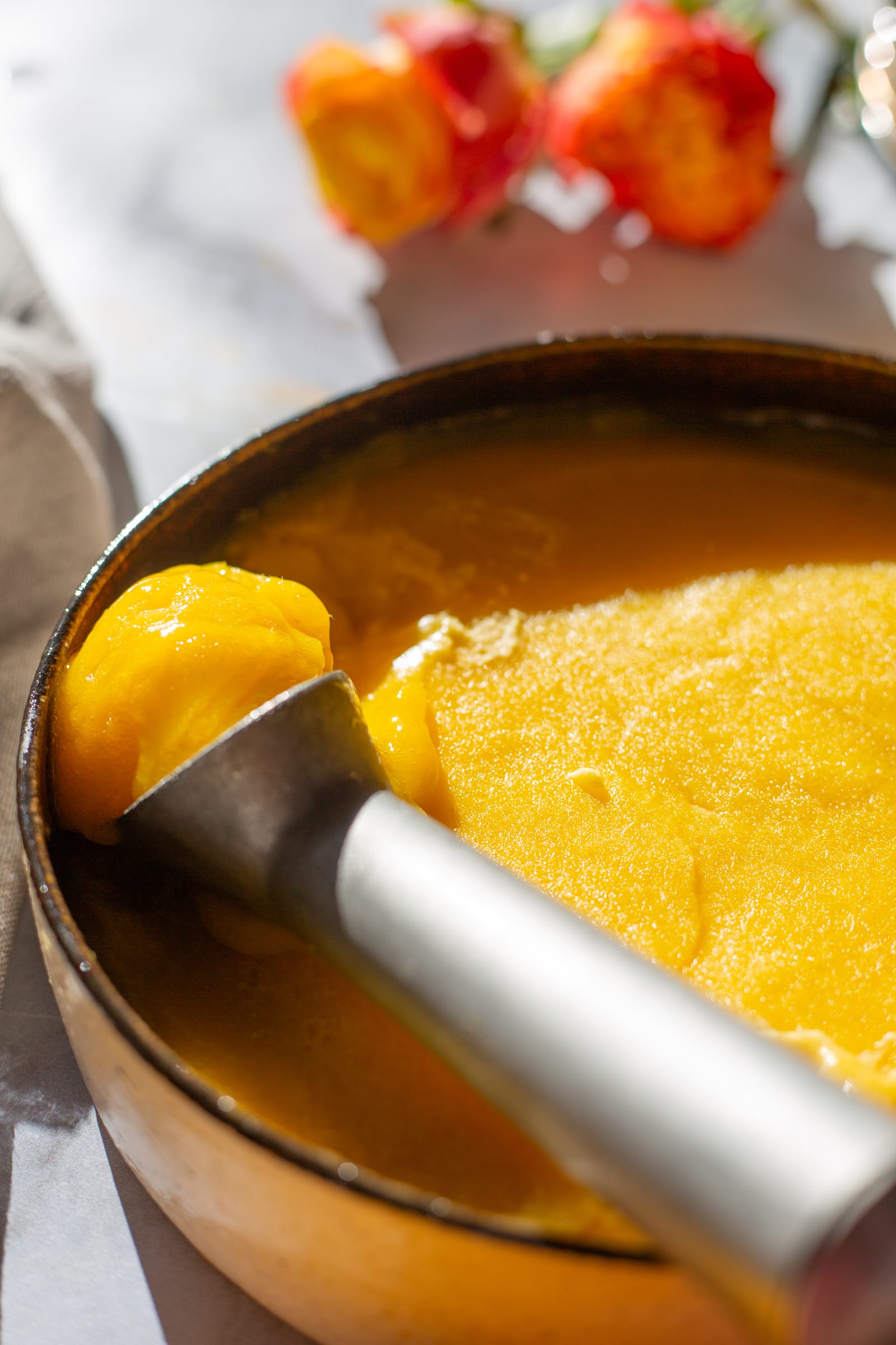 A scoop of mango and chilli sorbet in its dish, close up