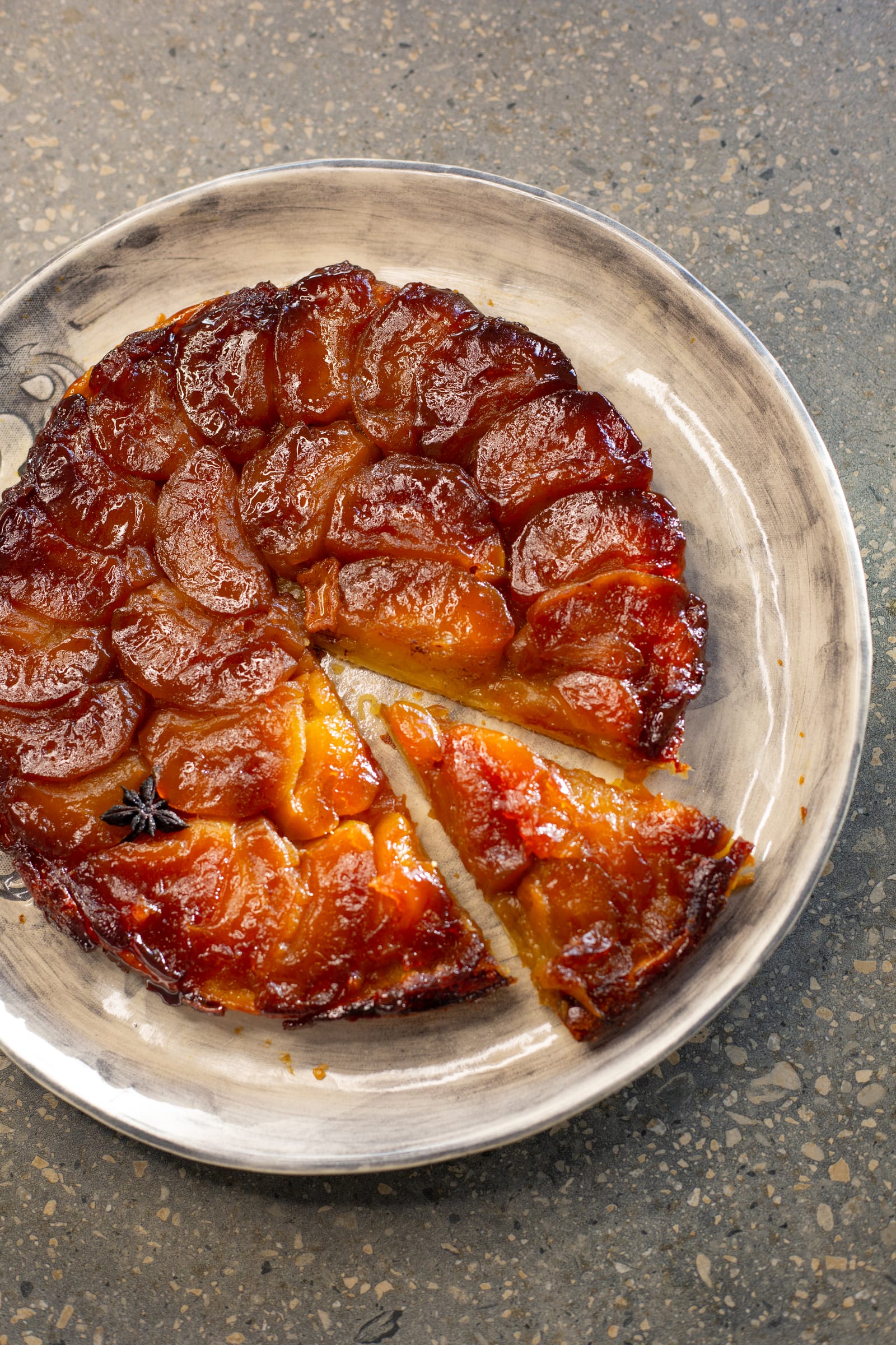 An apple tarte tatin with one wedge cut and pulled out, from above