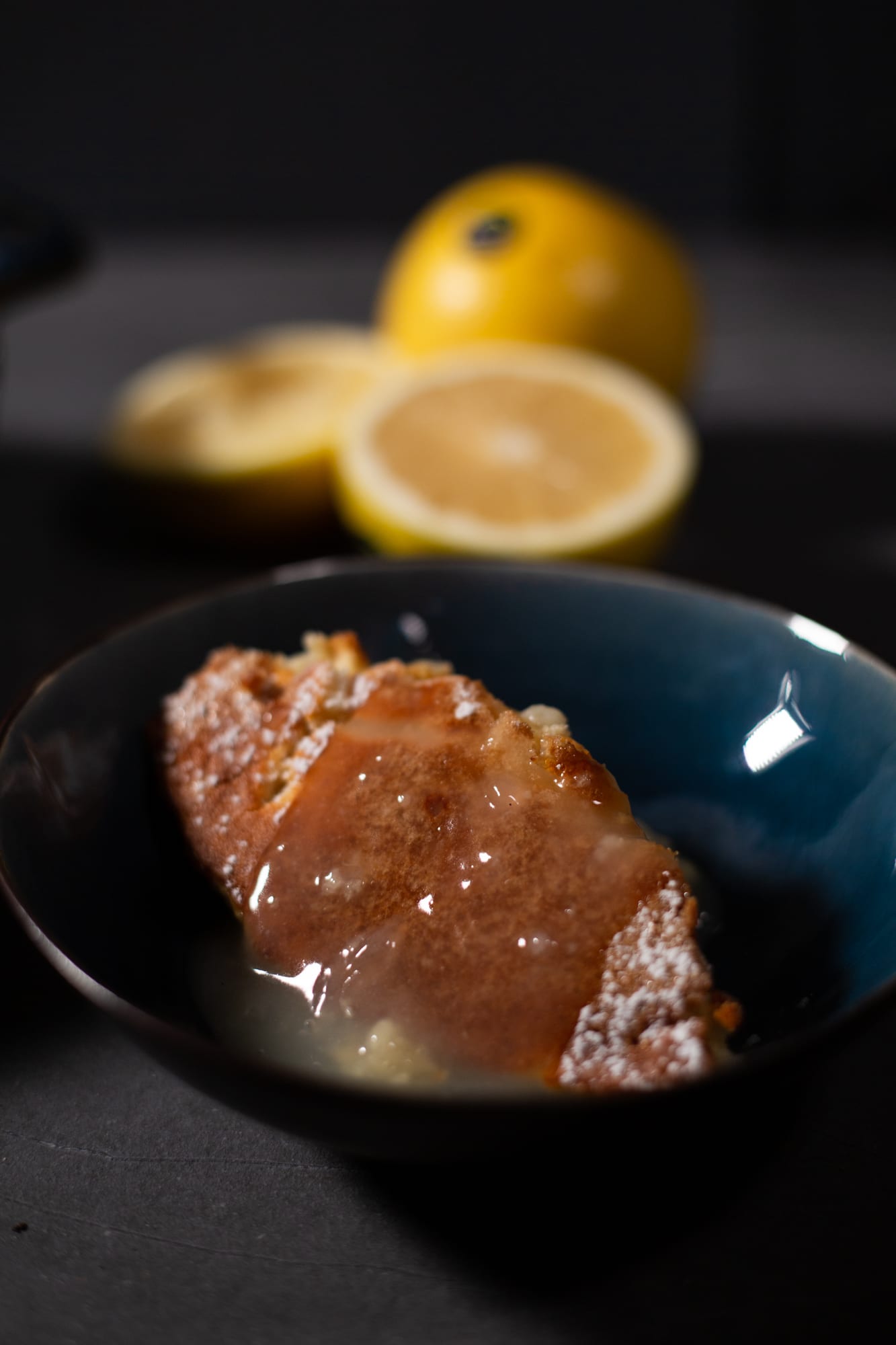 Pudding soaked in its own sauce, in a dark bowl