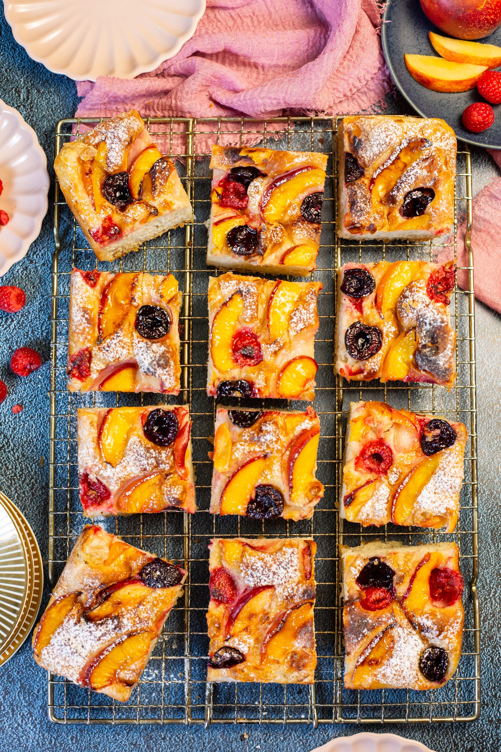 Squares of nectarine and cherry focaccia on a wire rack, from above