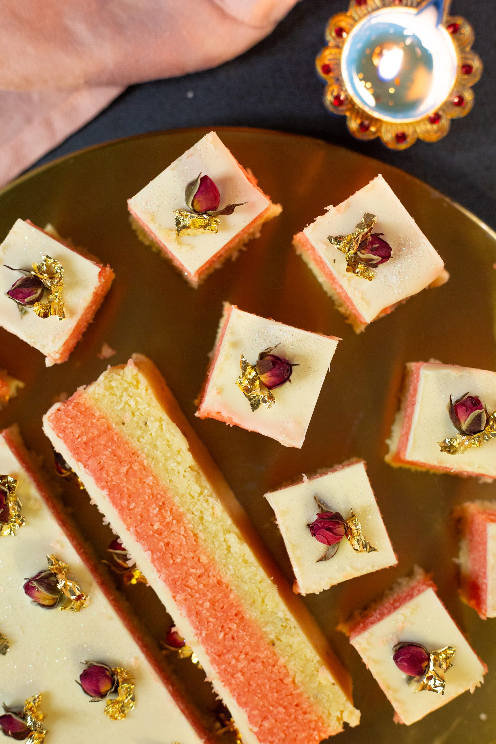 A kopra paak slab and cubes decorated with dried rosebuds and gold leaf, from above