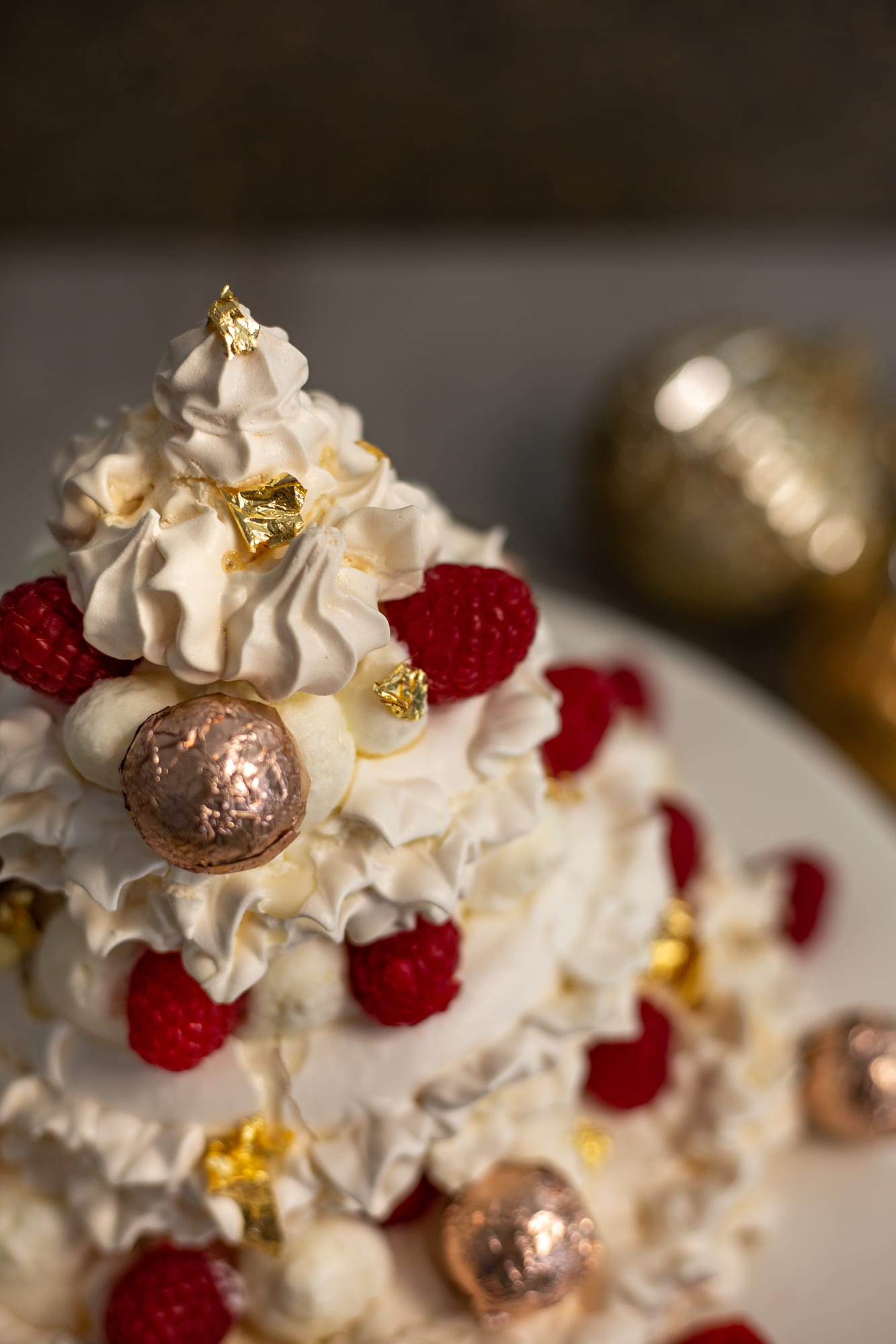 Close-up of the upper tiers of a Christmas tree pavlova with raspberries