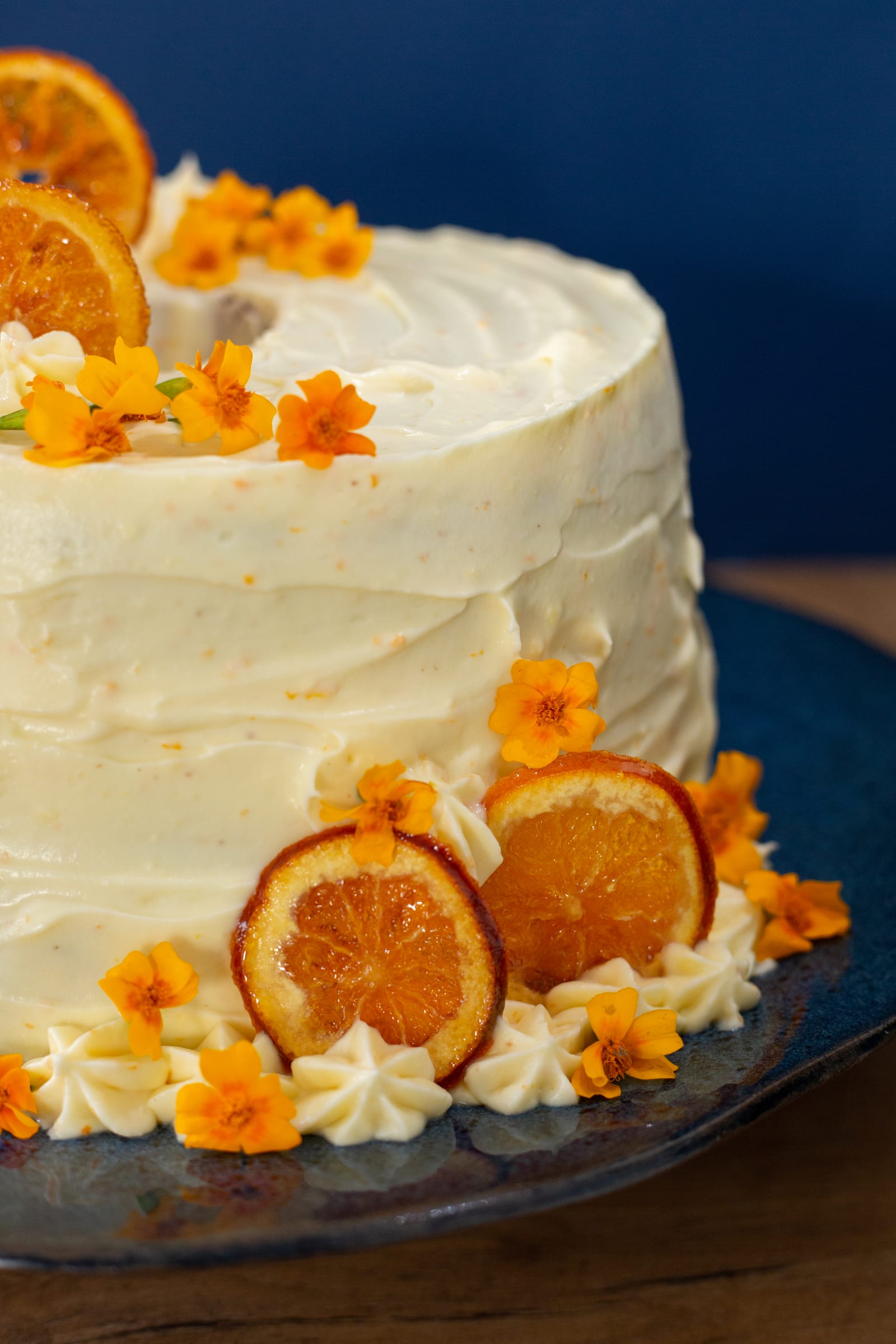 Candied orange slices and flowers at the base of the orange cream chiffon cake