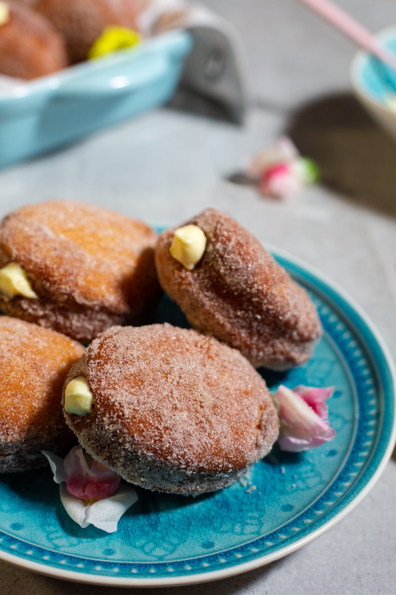 Close-up of doughnuts filled with milk tart mousse on a teal plate
