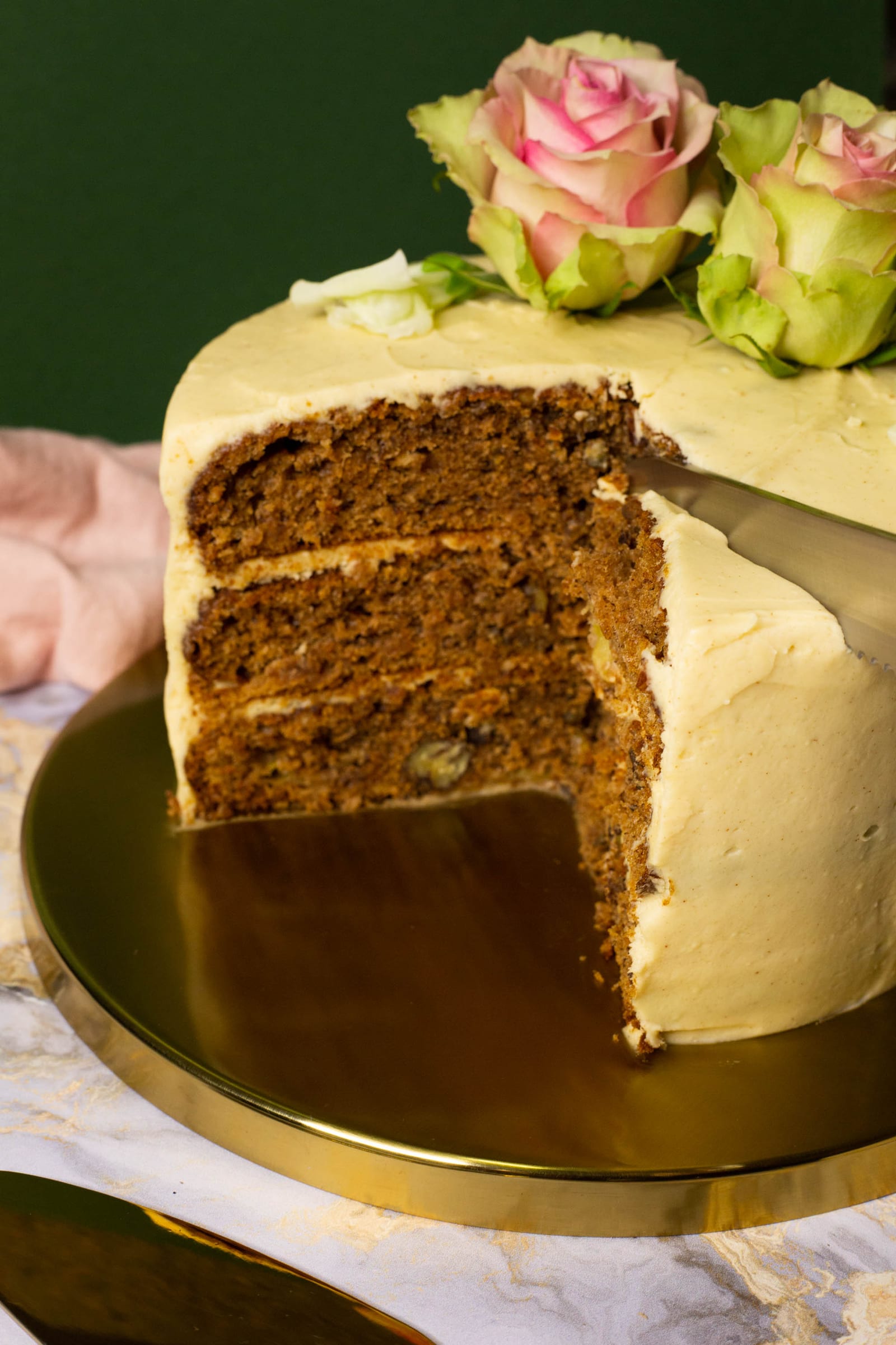 A slice being lifted out of a hummingbird cake on a gold server