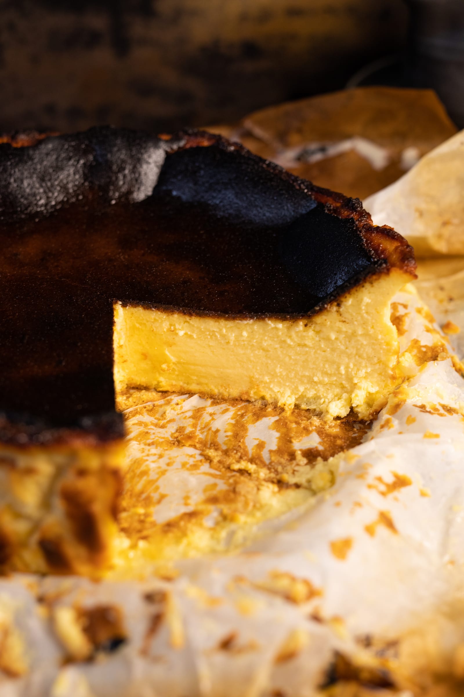 Close-up of the cut Basque cheesecake, showing the silky yellow interior under the burnt top