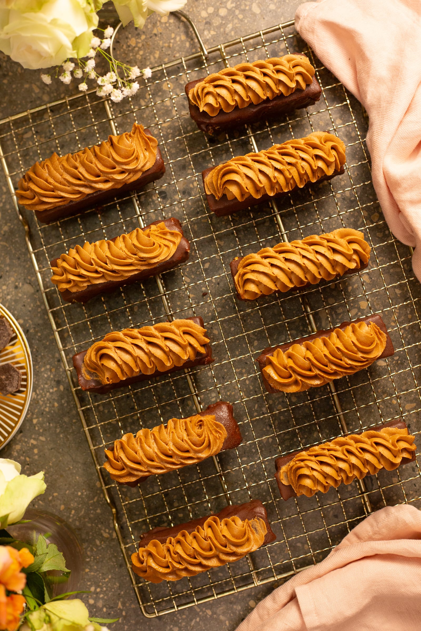 A full rack of channa magaj and chocolate brownie fingers from above, with flowers and a pink napkin