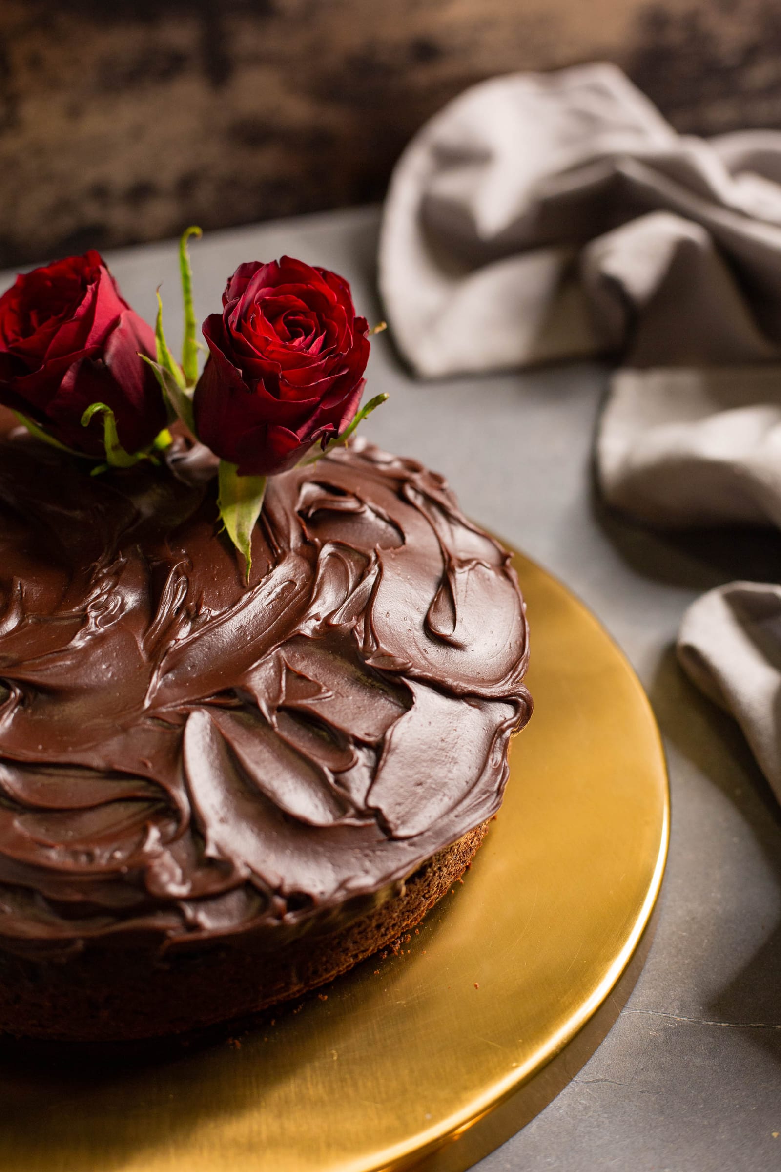 Close-up of the swirled ganache and red roses on a chocolate and beetroot cake