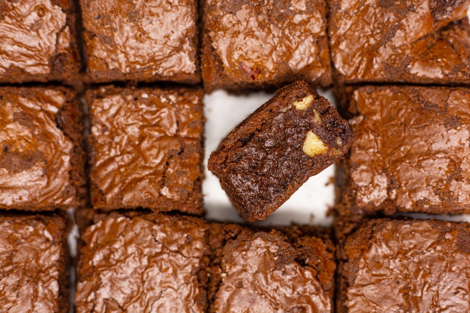 Chocolate brownies cut into squares with one turned on its side to show the fudgy inside, from above