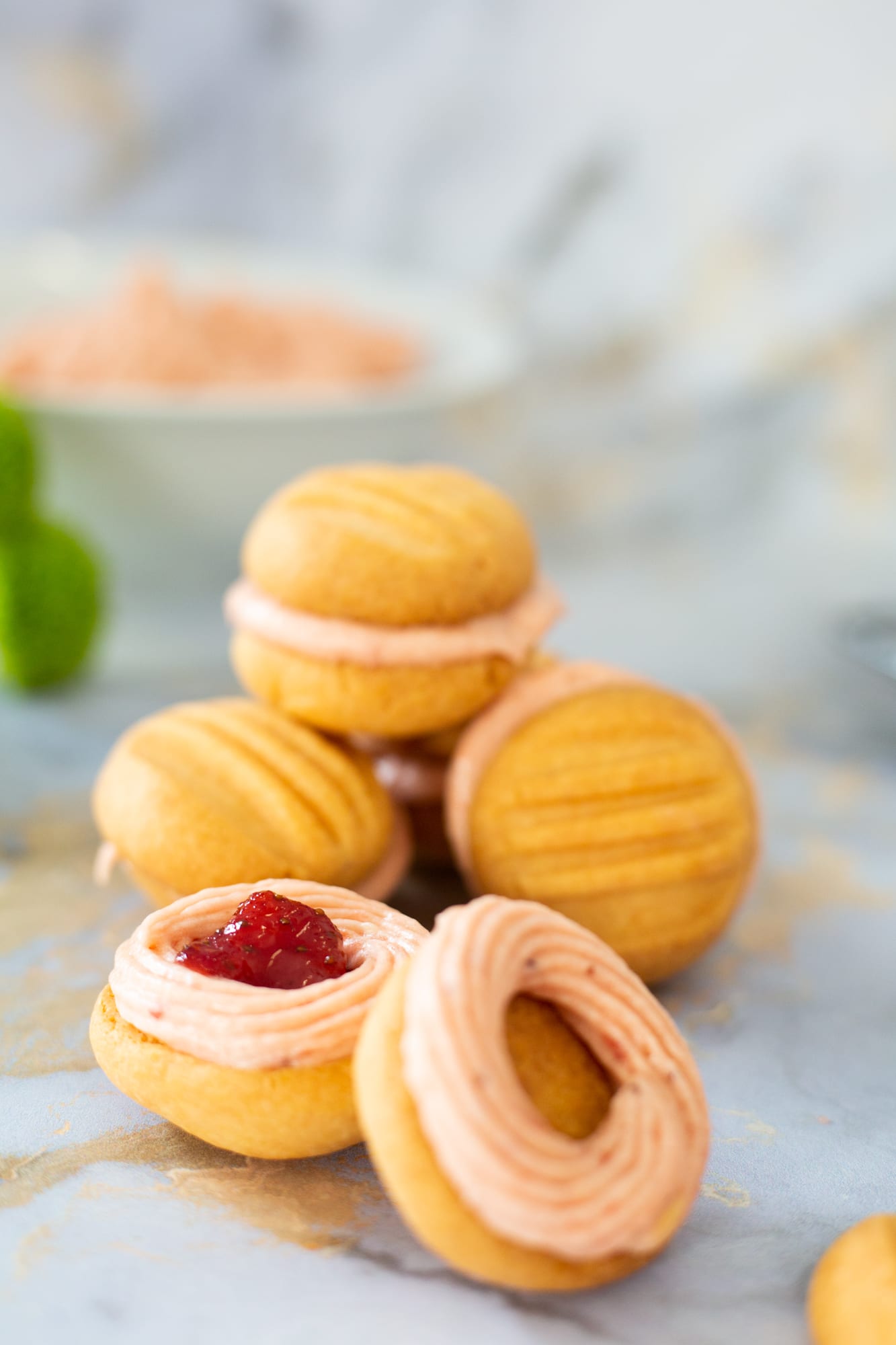 A pile of custard and jelly biscuits with a jam-centred one in front