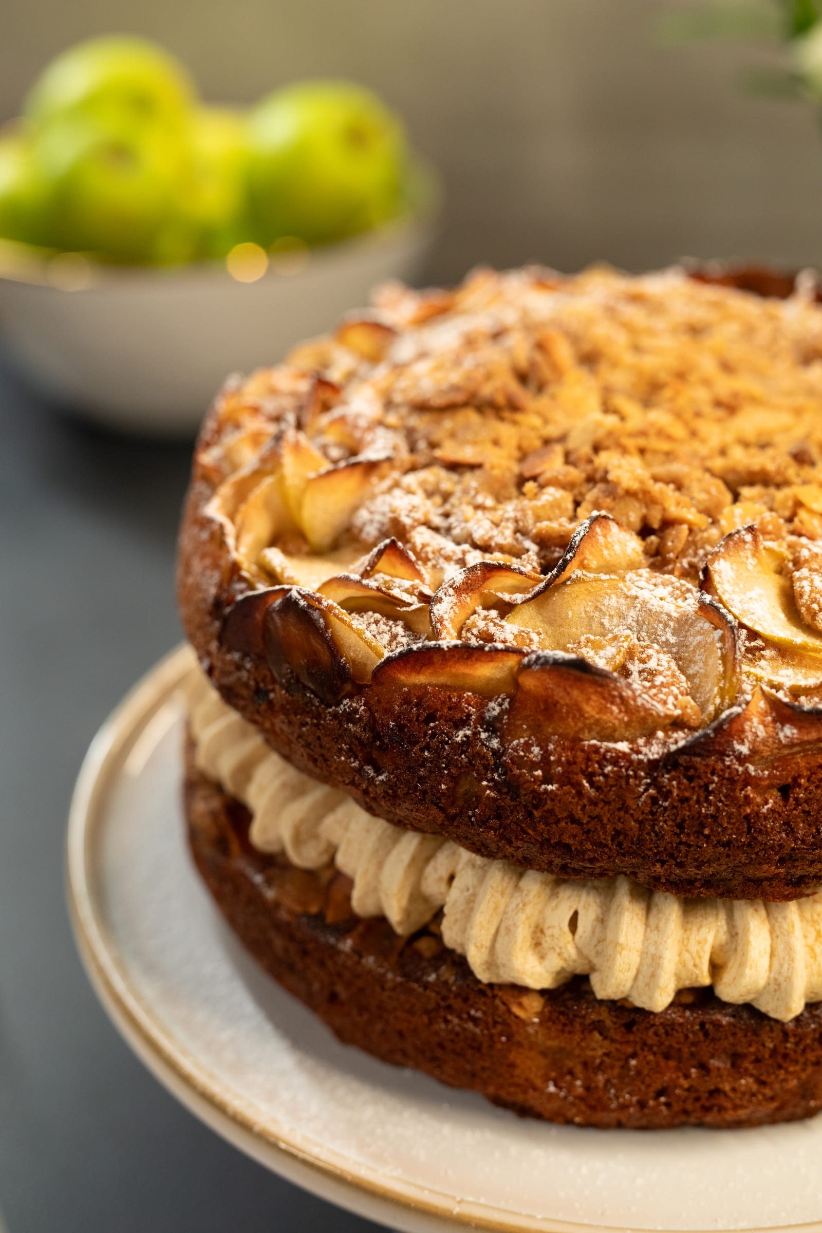 Close-up of the apple crumble cake's sliced-apple crown and maple cream cheese icing