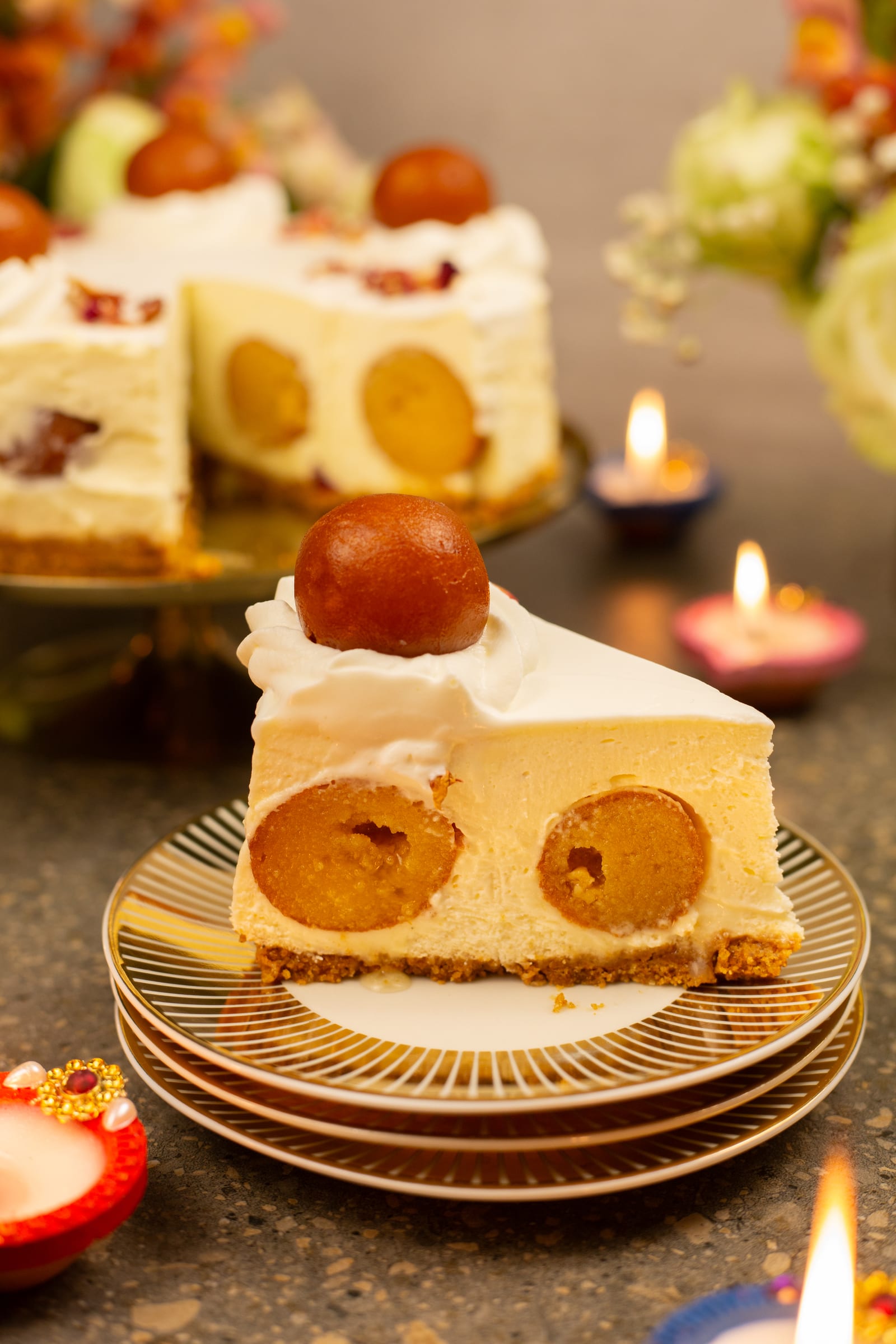 A slice of cheesecake showing gulab jamun hidden inside