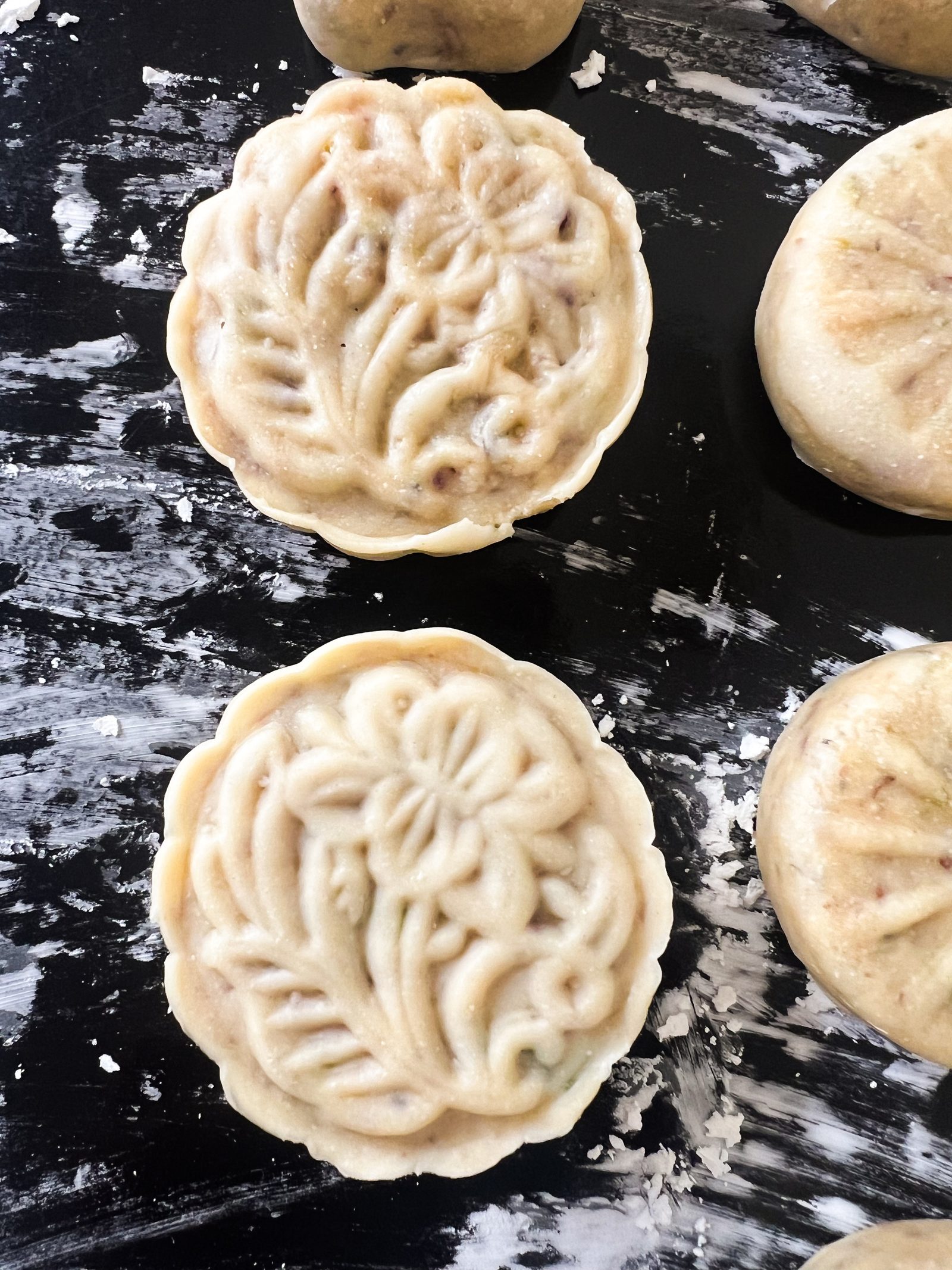 Unbaked mawa ghari from above, pressed with a floral mould pattern