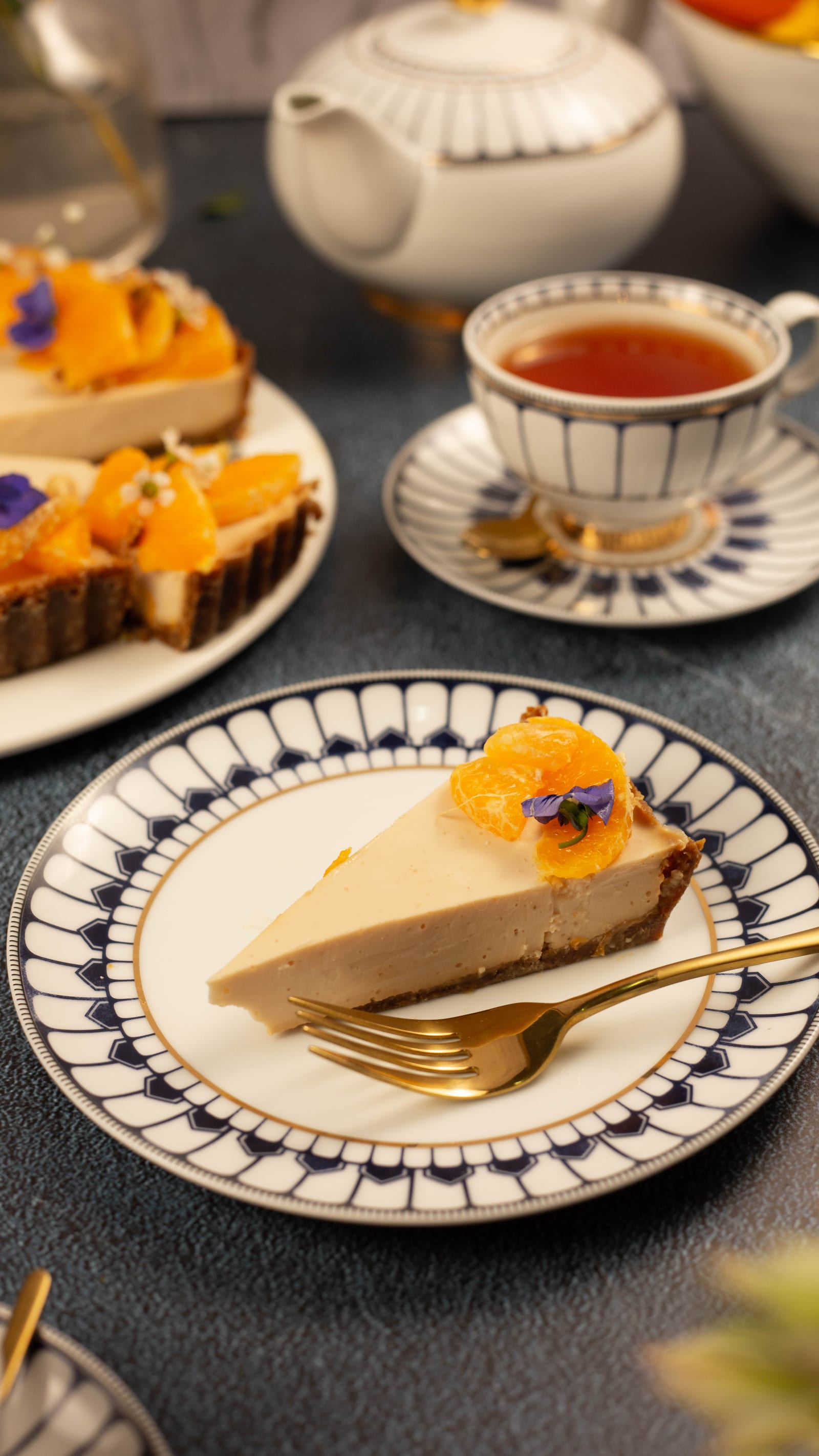 A slice of rooibos panna cotta tart beside a cup of tea